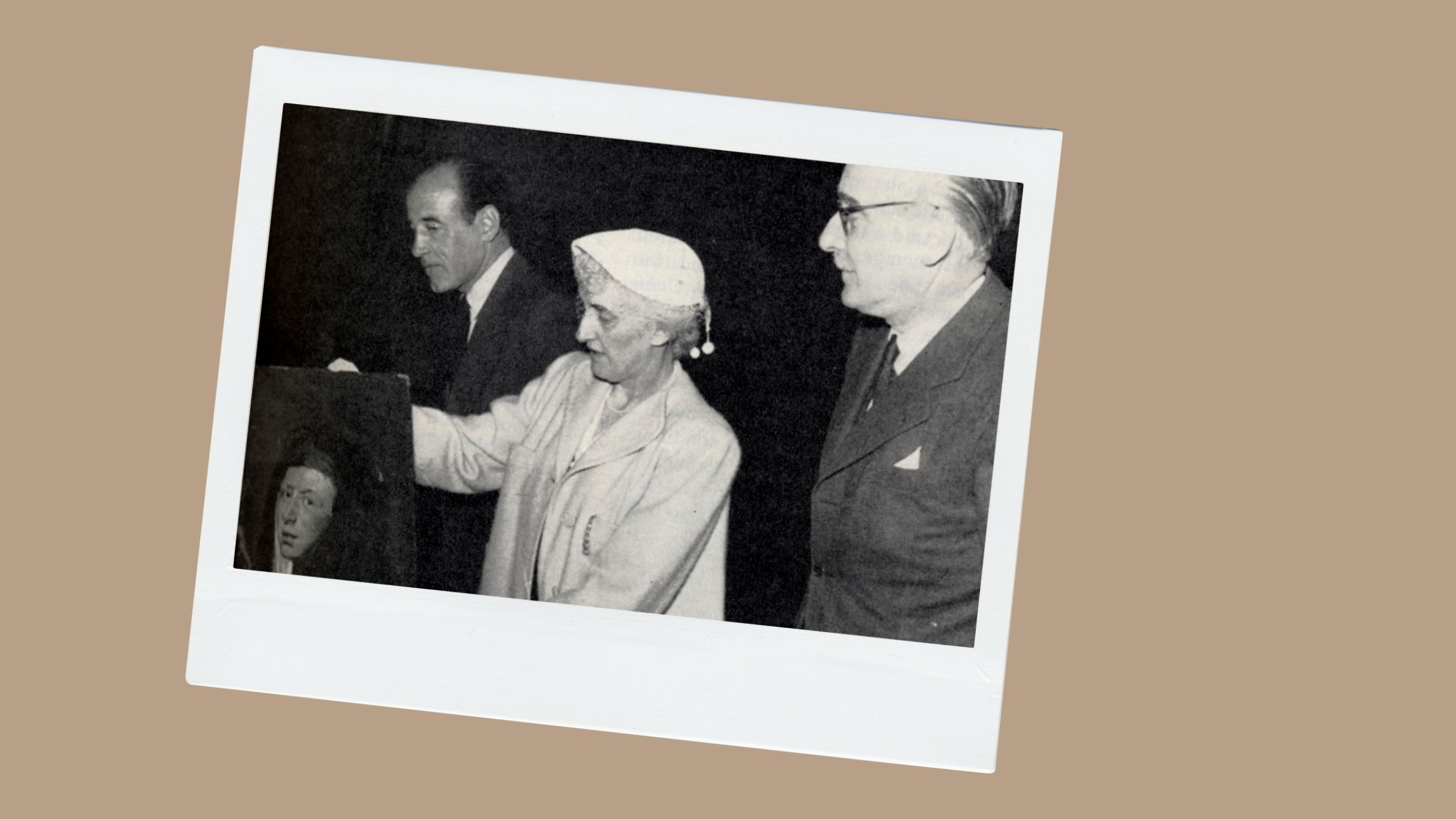 A woman holding a painting flanked by two men (Smith College Special Collections)