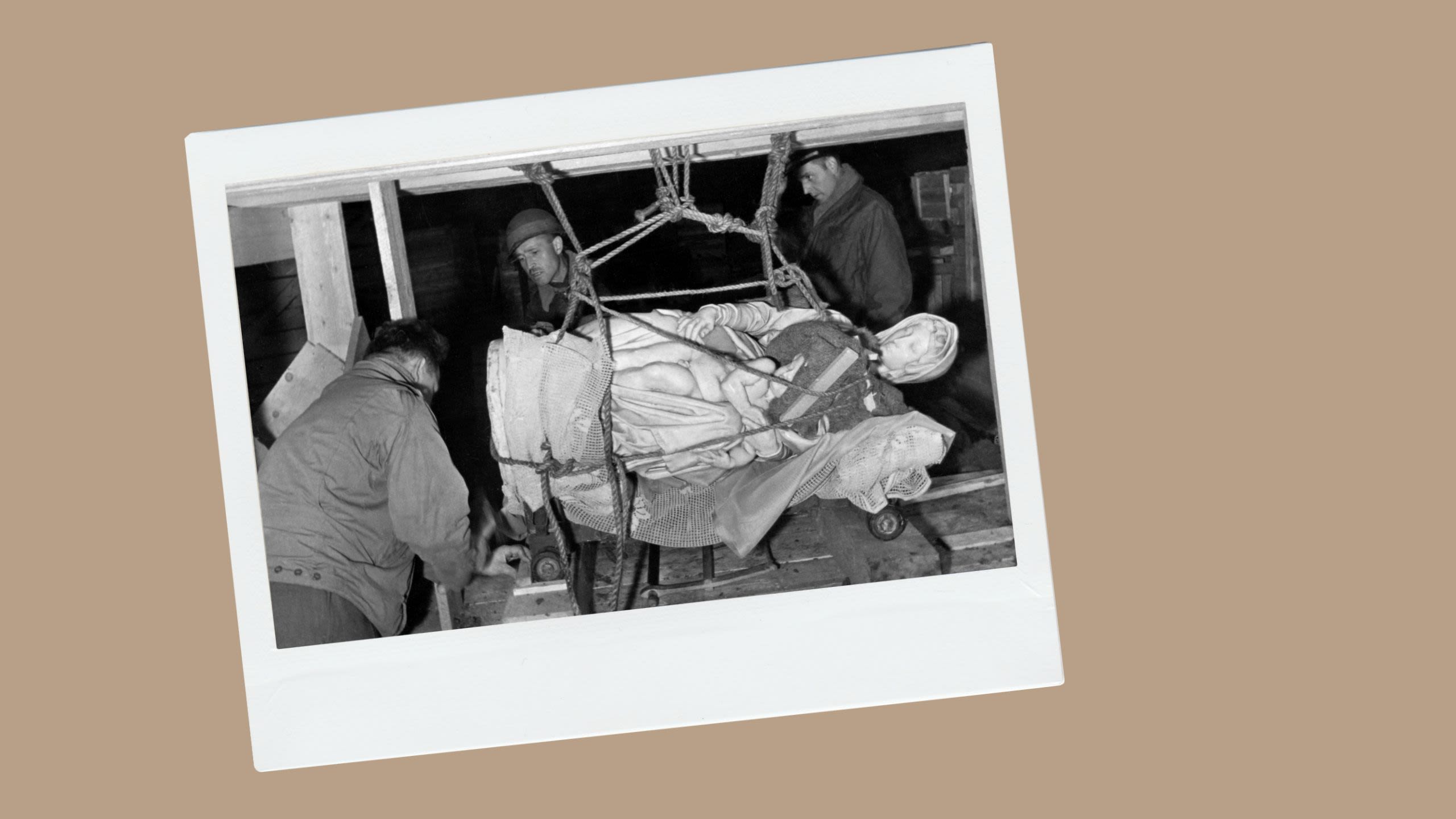 A statue is hoisted up by soldiers (© Pictures from History/Universal Images Group/Getty Images)