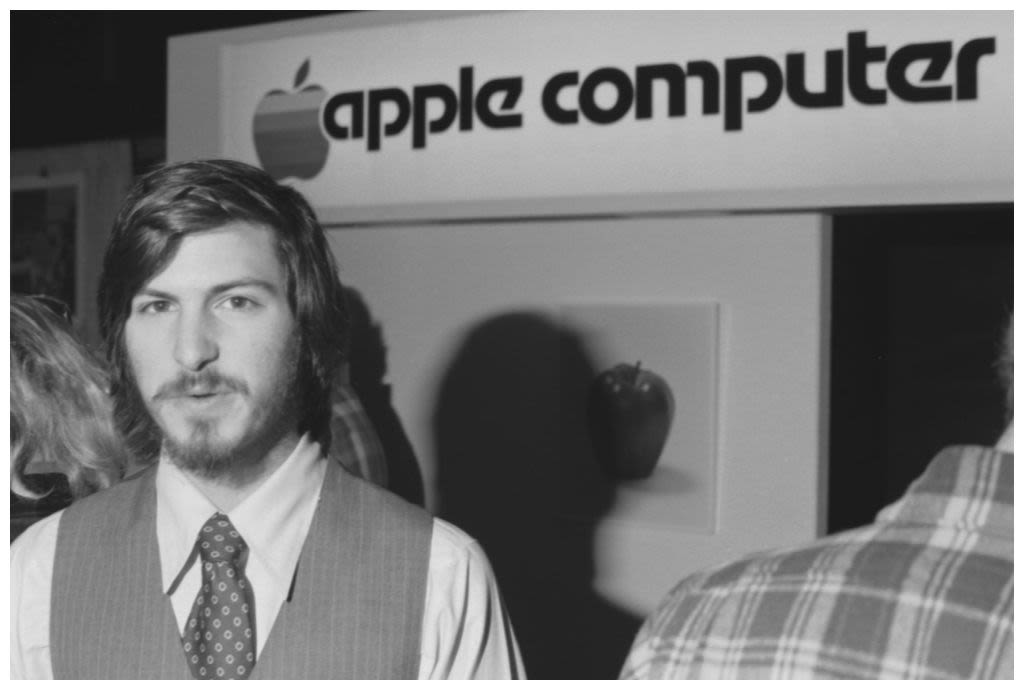 Steve Jobs standing in front of an "Apple Computer" sign (© Tom Munnecke/Getty Images