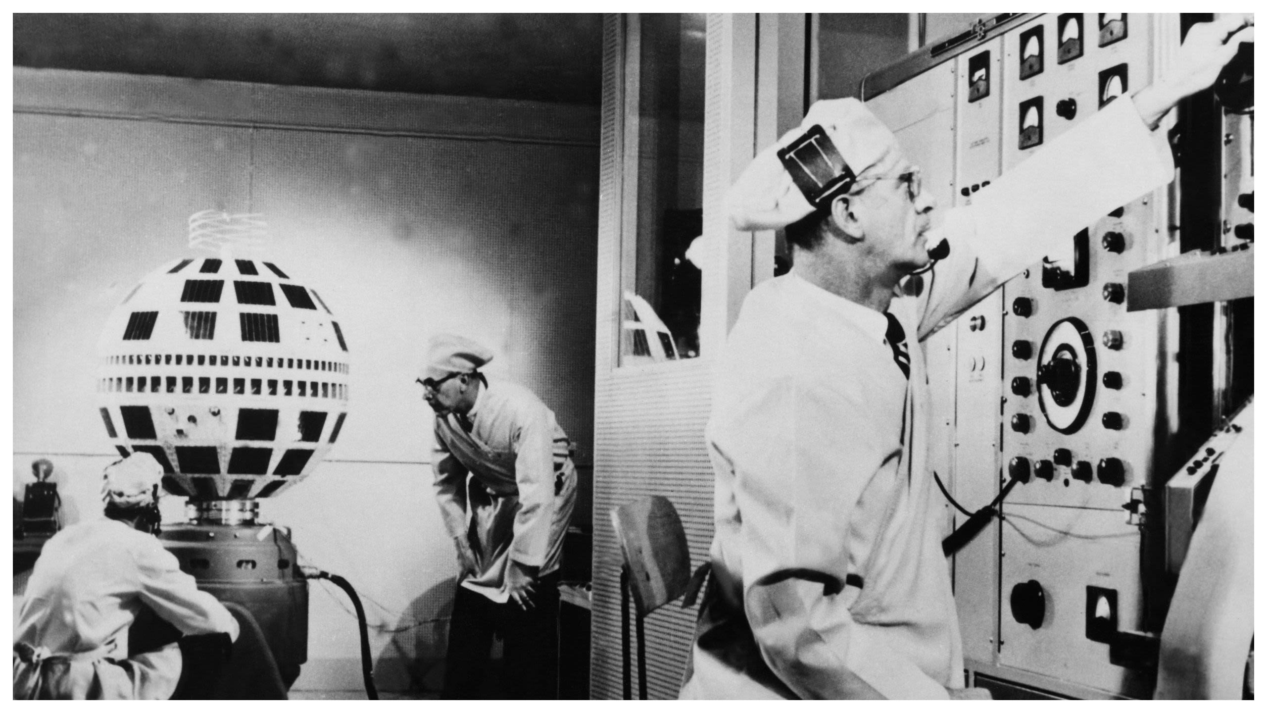 Technicians examine spherical Telstar communications satellite inside Bell Labs lab, early 1960s (© Keystone-France/Getty Images)