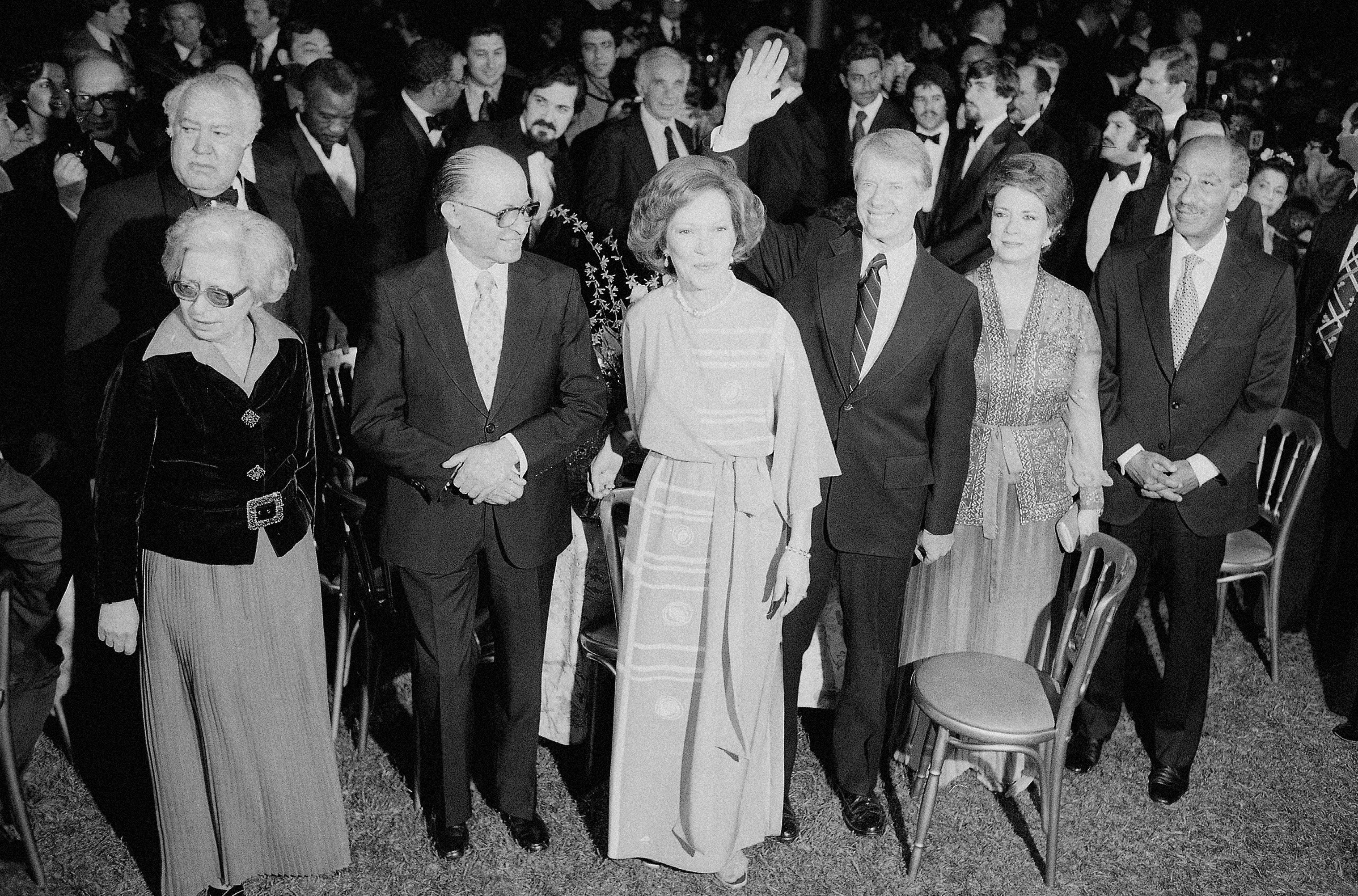 Jimmy Carter waving, Menachem Begin, Anwar Sadat, first ladies (© AP)