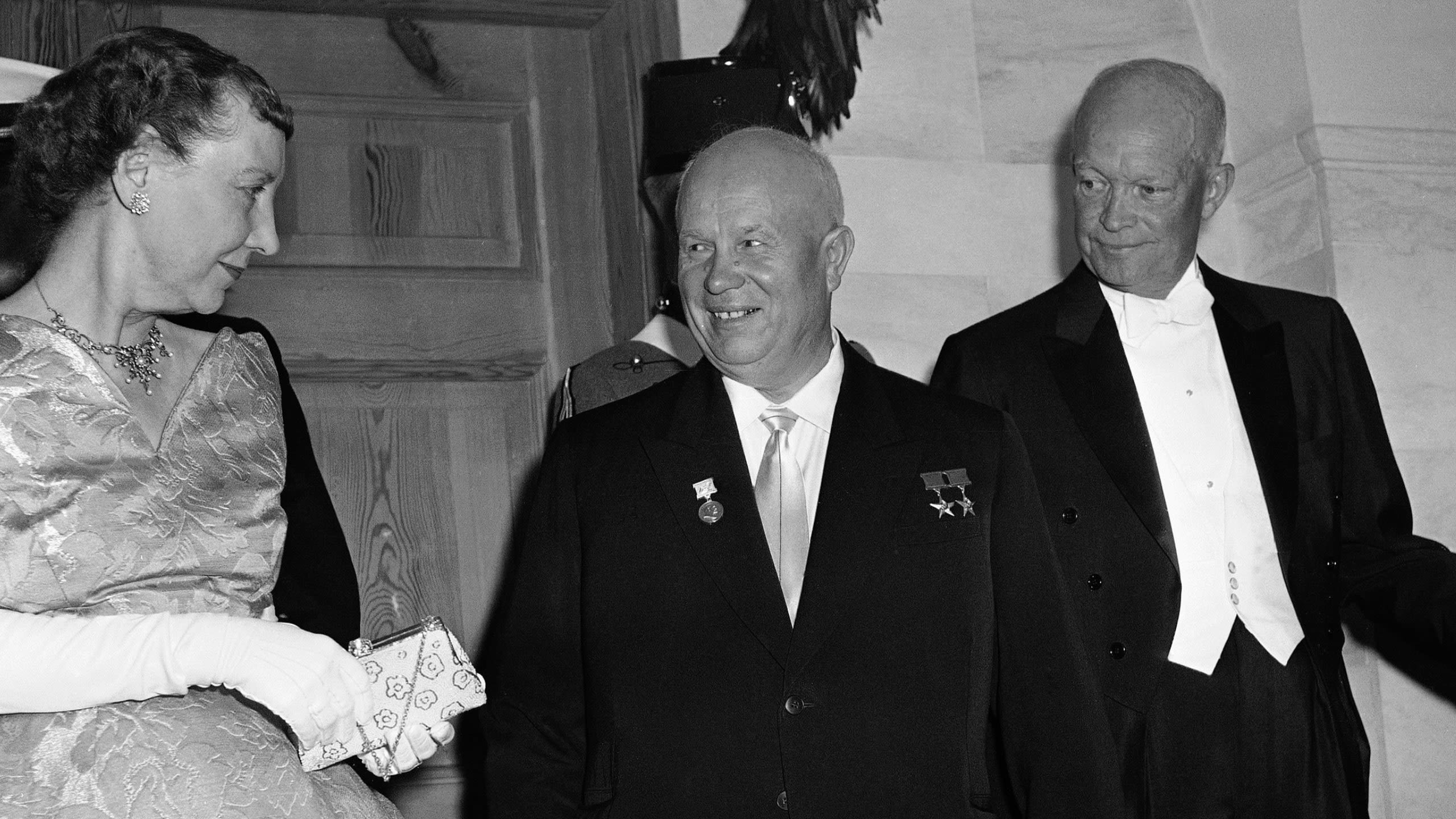 Soviet Premier Nikita Khrushchev between President Dwight Eisenhower and Khrushchev's wife (© Bob Schutz/AP)