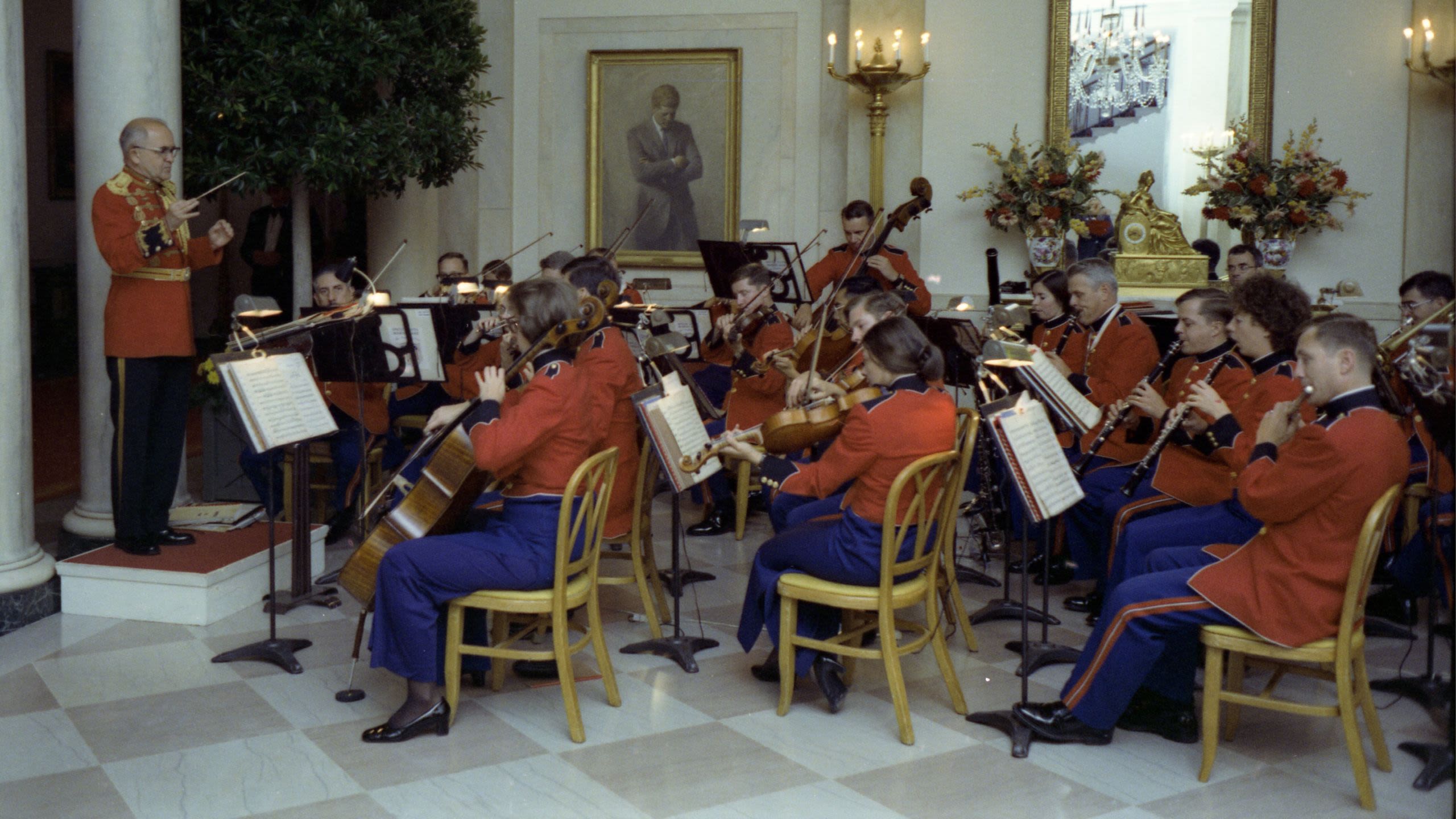 A conductor on a riser leading seated musicians, all in uniform (White House Photographic Office/Karl Schumacher)