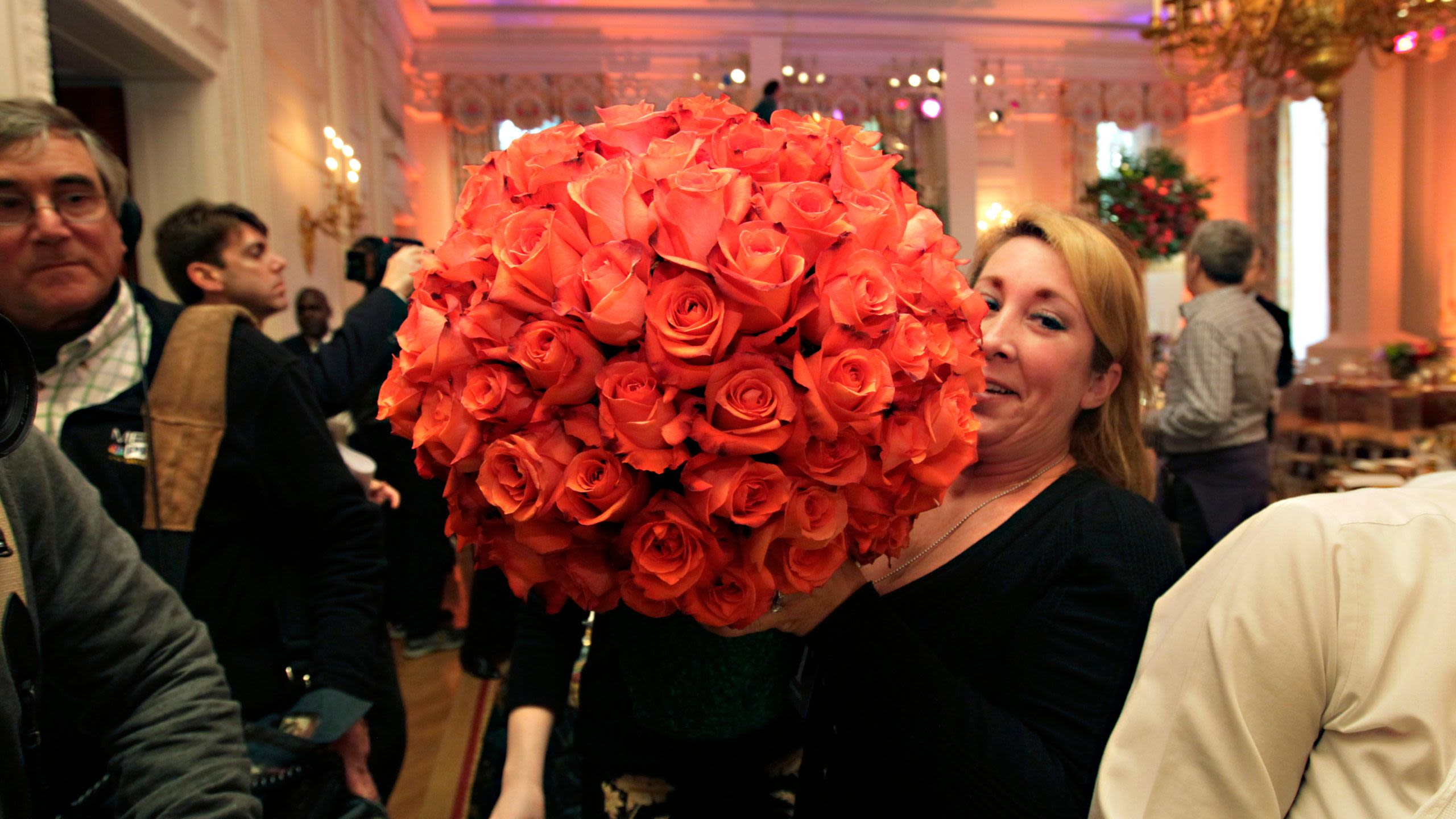 Woman carrying arrangement of roses (© Carolyn Kaster/AP)