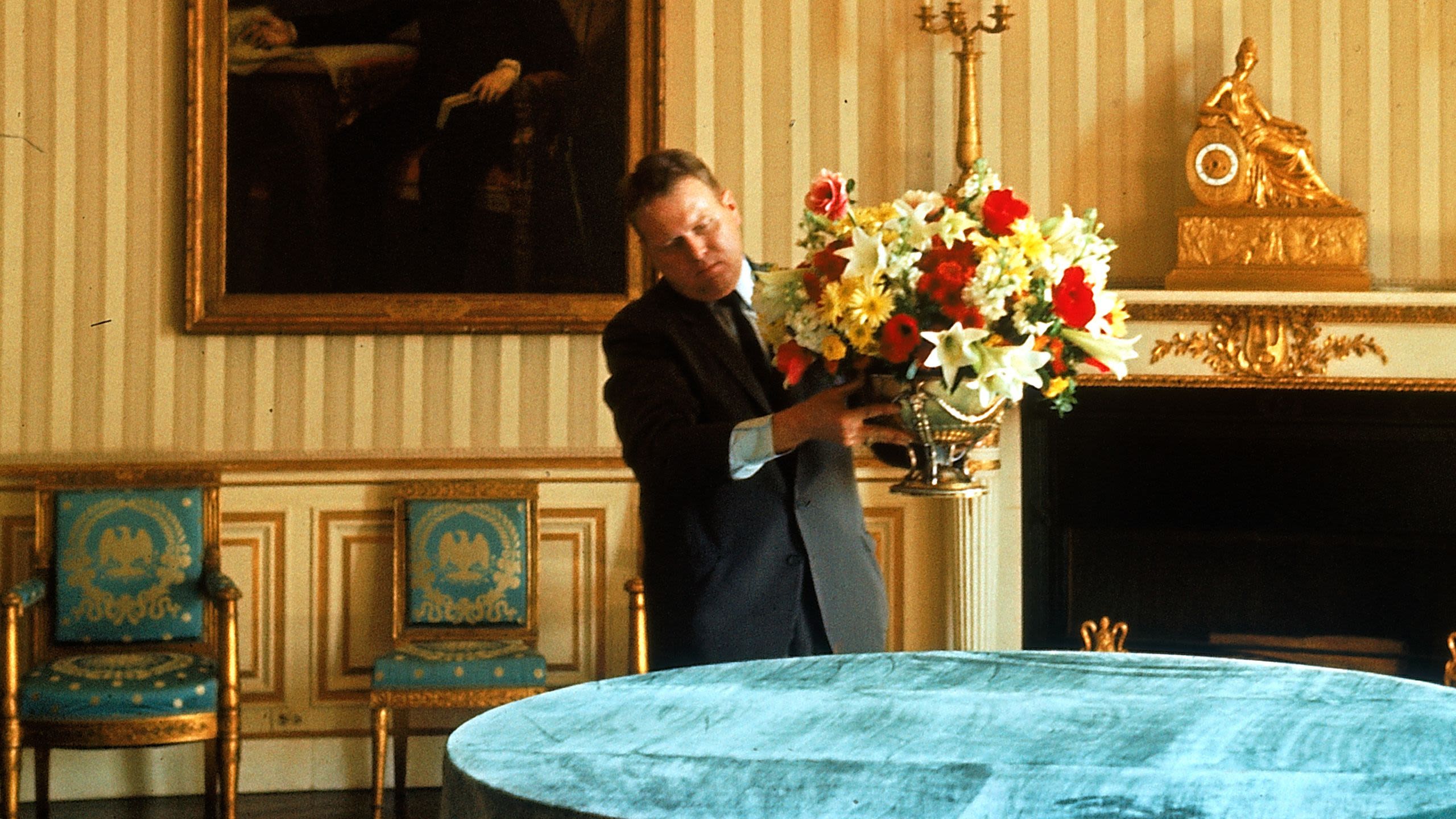 Rusty Young placing floral arrangement on table (© Mark Kauffman/Getty Images)