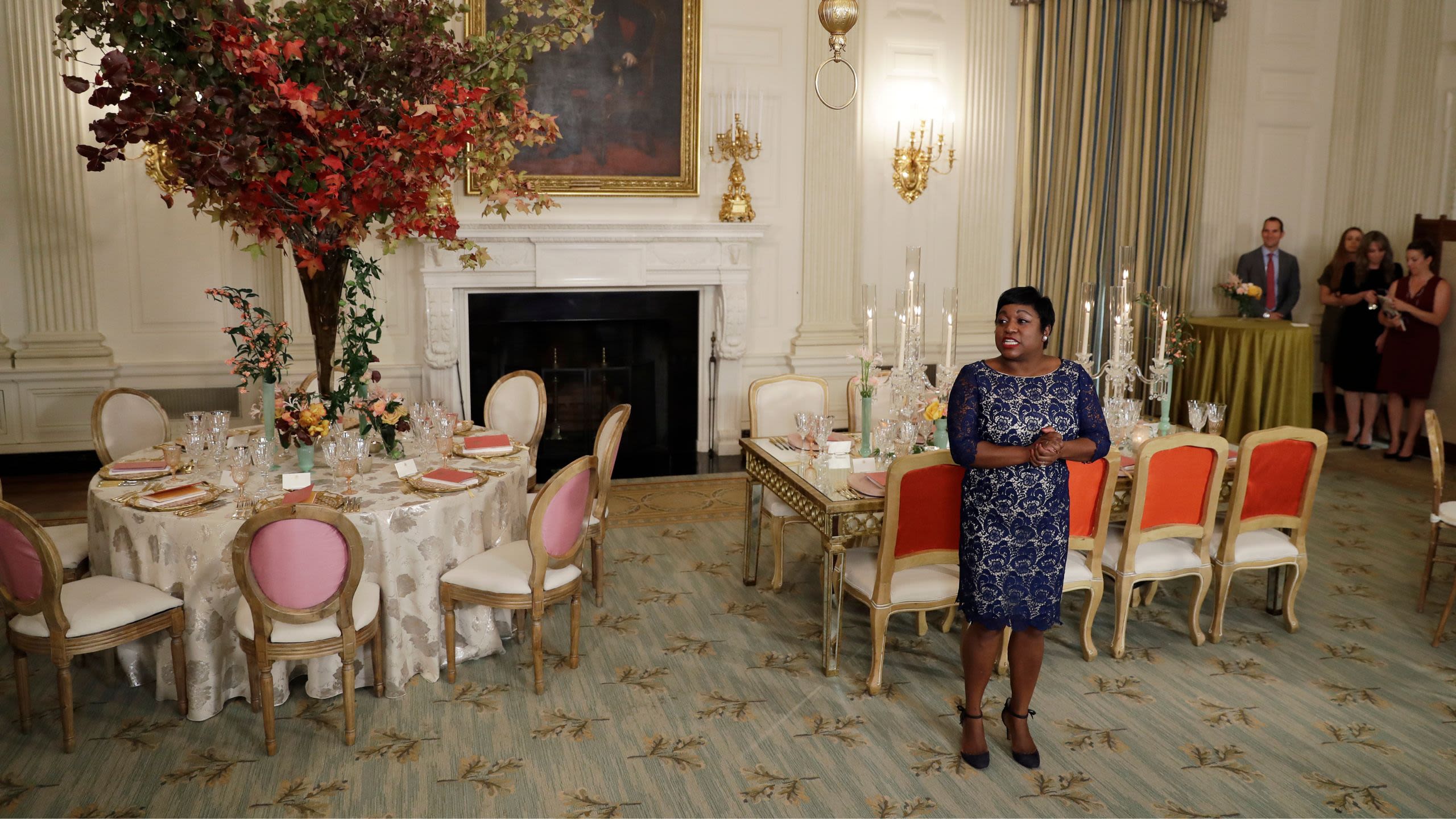 Deesha Dyer speaking in front of tables set for dinner. (© Carolyn Kaster/AP)