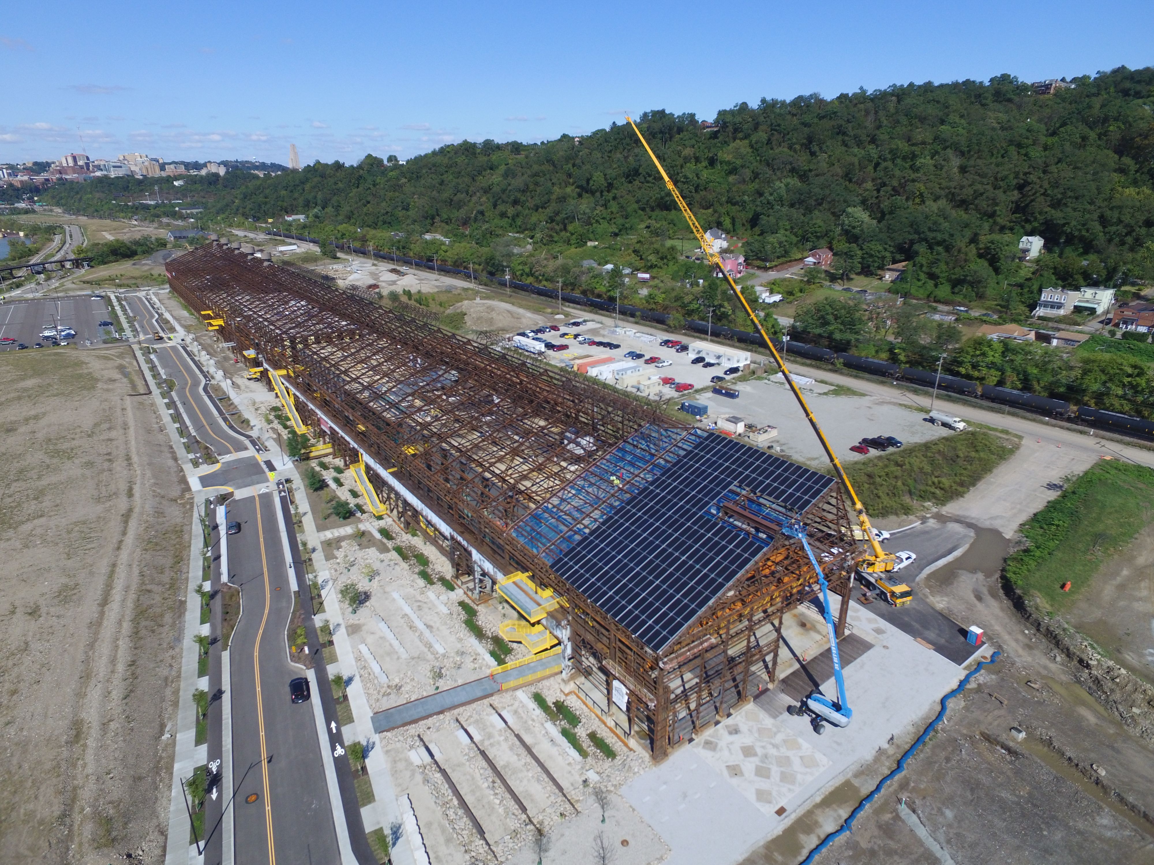 A crane hoists solar panels to the roof of Mill 19.