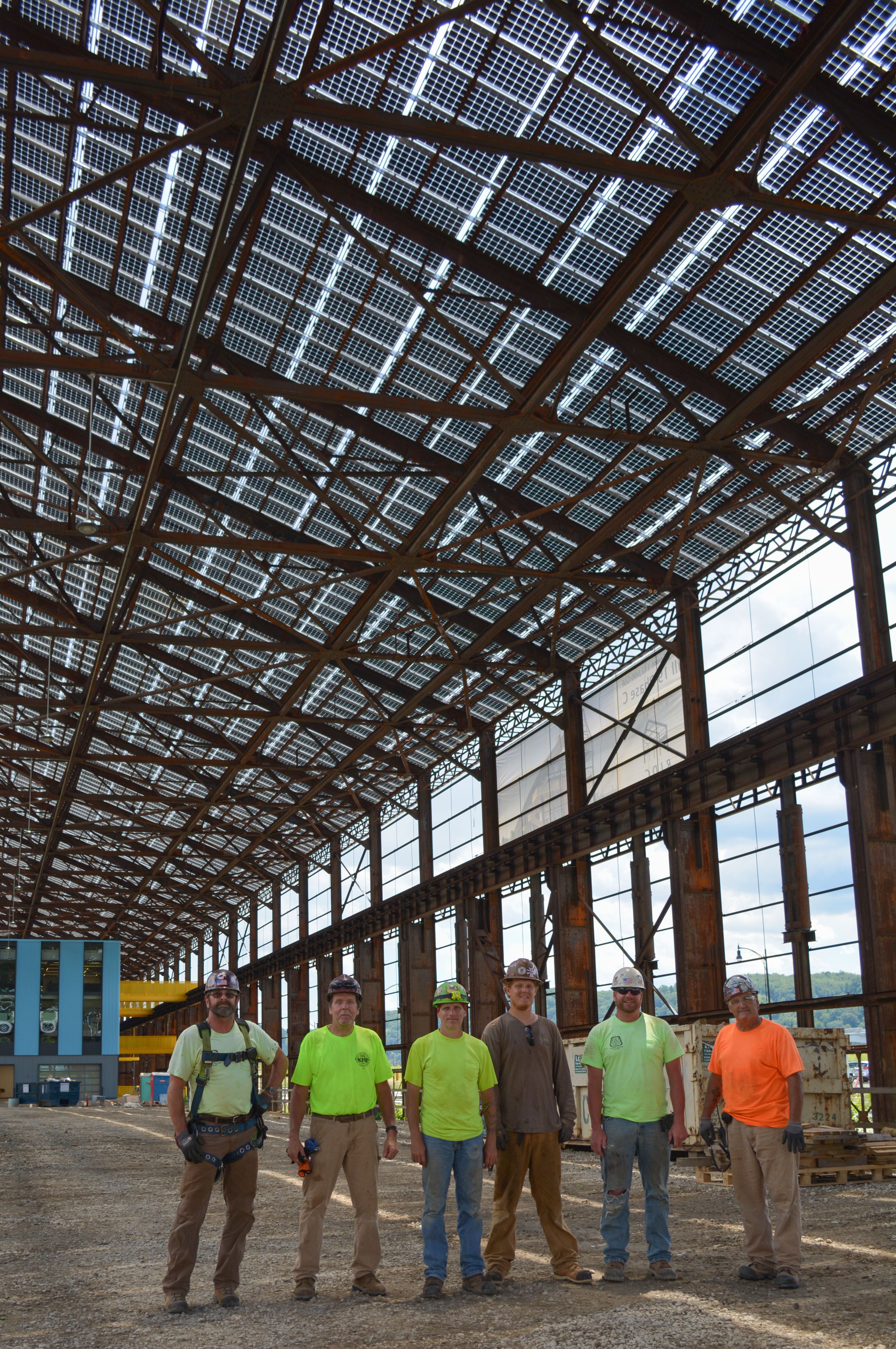 Tim Sippey, second from right,  and crew as the Mill 19 arrays are being prepared to be hoisted onto the roof, June 2020