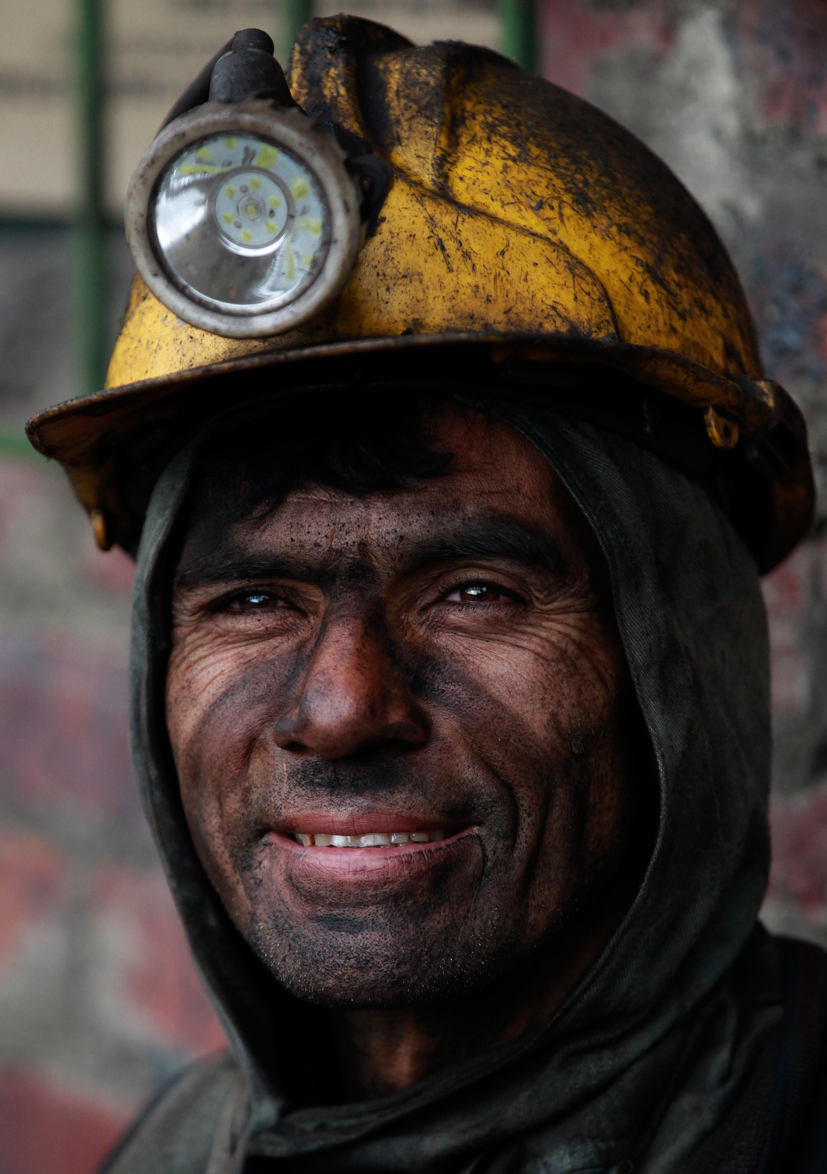 Armando Pinzon smiles toward the camera as he rests from working at at La Flauta coal mine in Tausa, Colombia, Tuesday, Sept. 24, 2013.