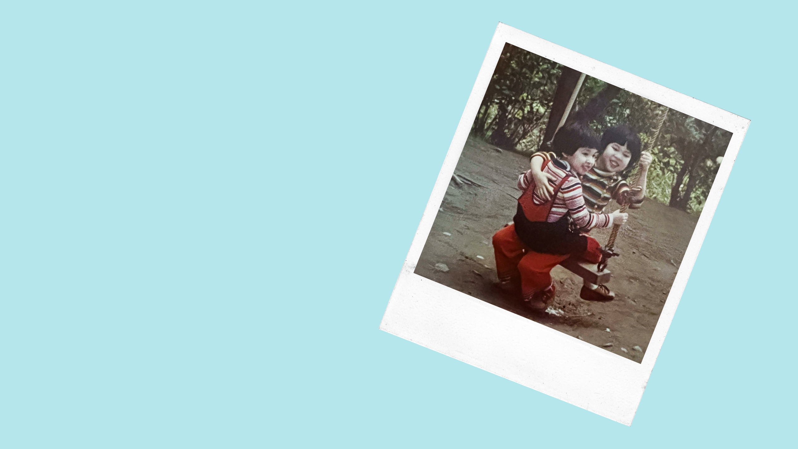 two young children share a swing