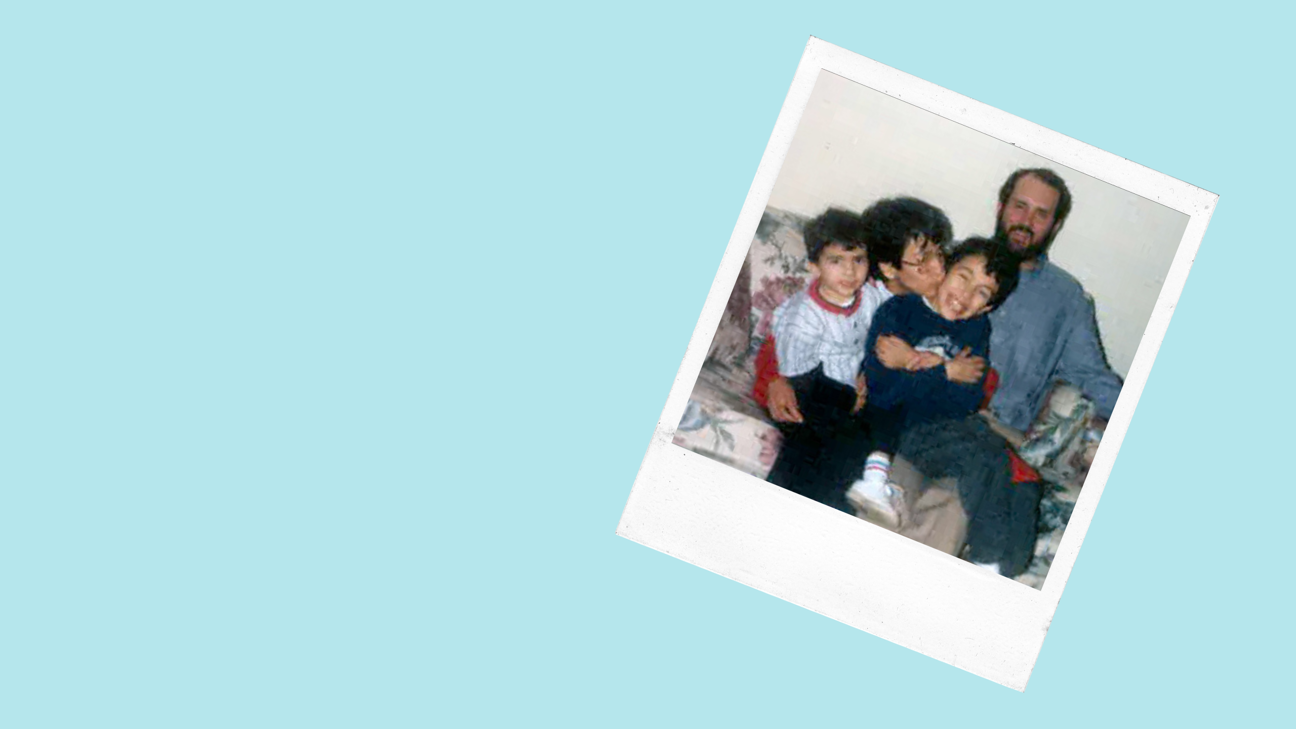 two adults and two children sit on a couch and smile