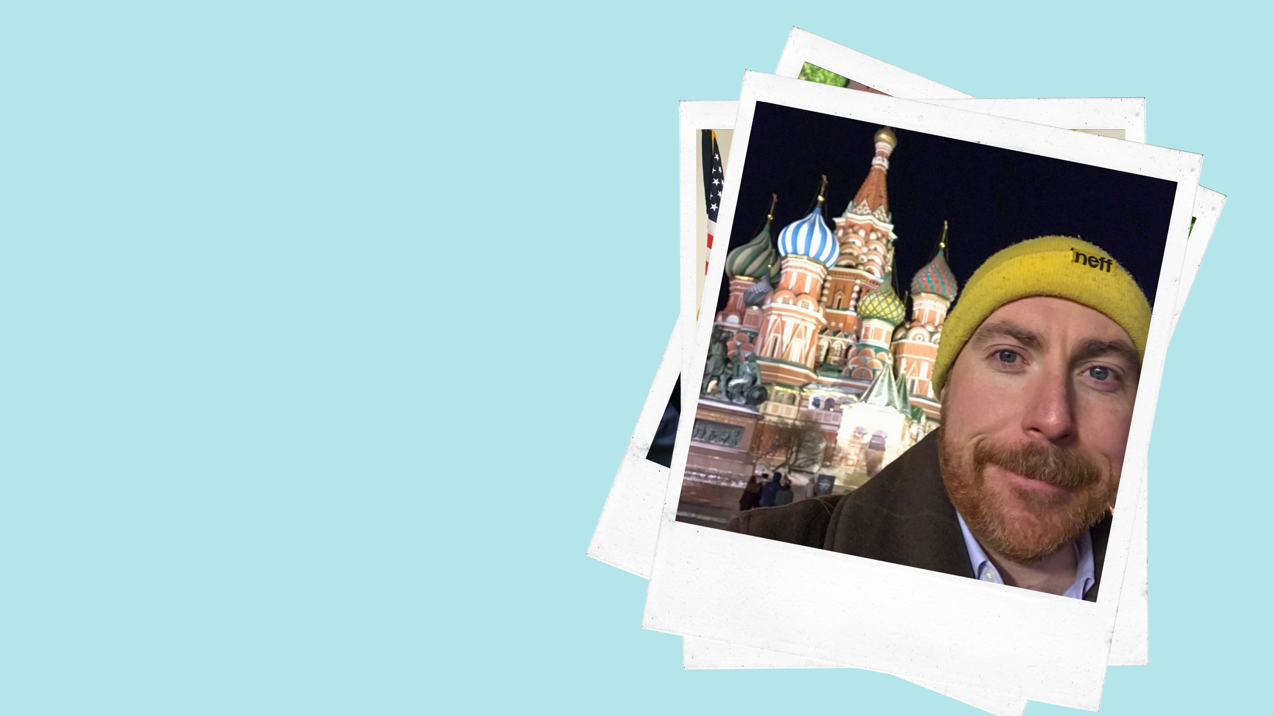 a man wearing a knit cap poses in front of a Russian-style cathedral