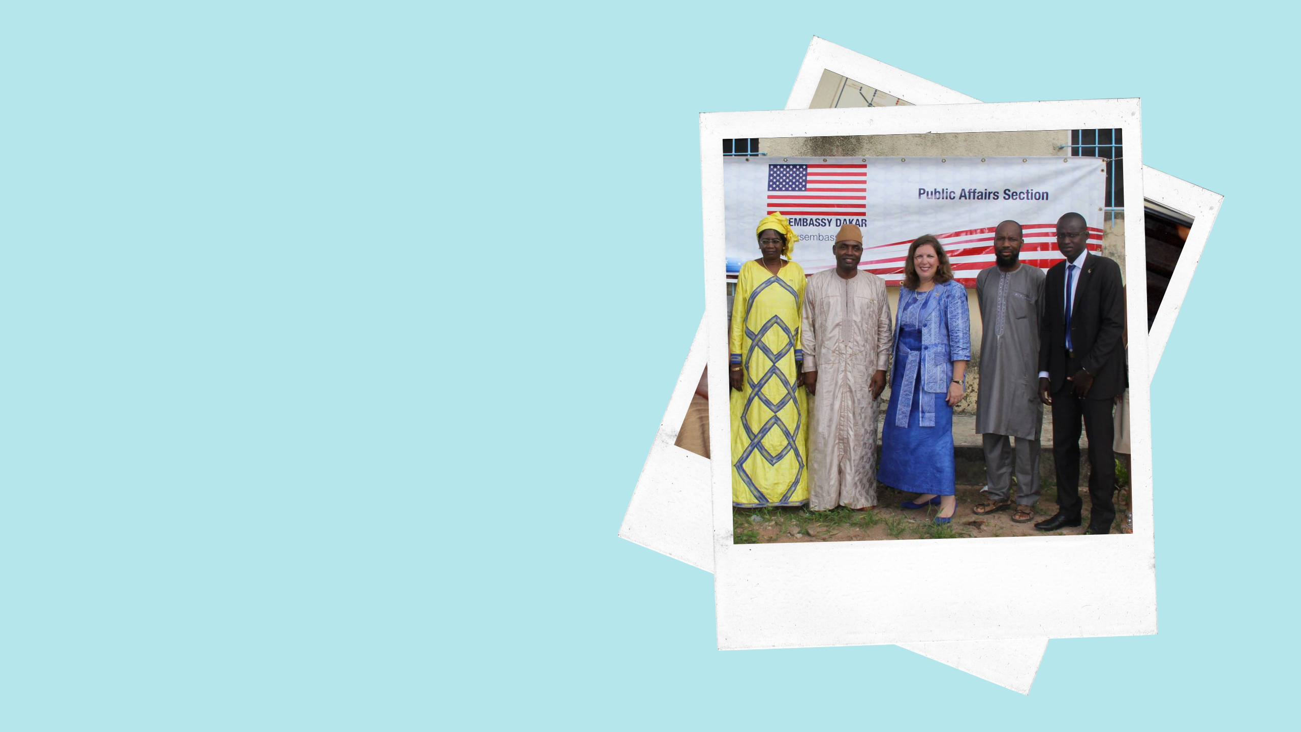 two women and three men pose in front of a banner that reads "Embassy Dakar Public Affairs Section"