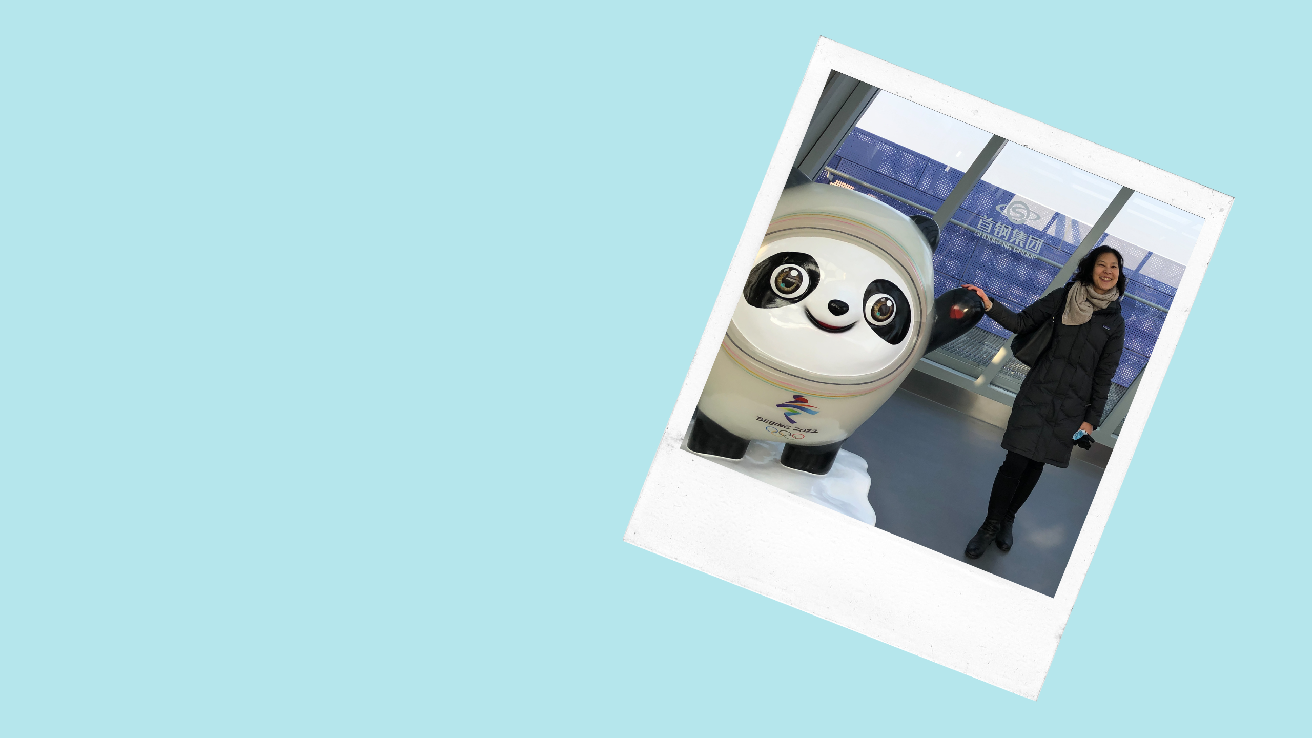 a woman stands next to the statue of a large panda