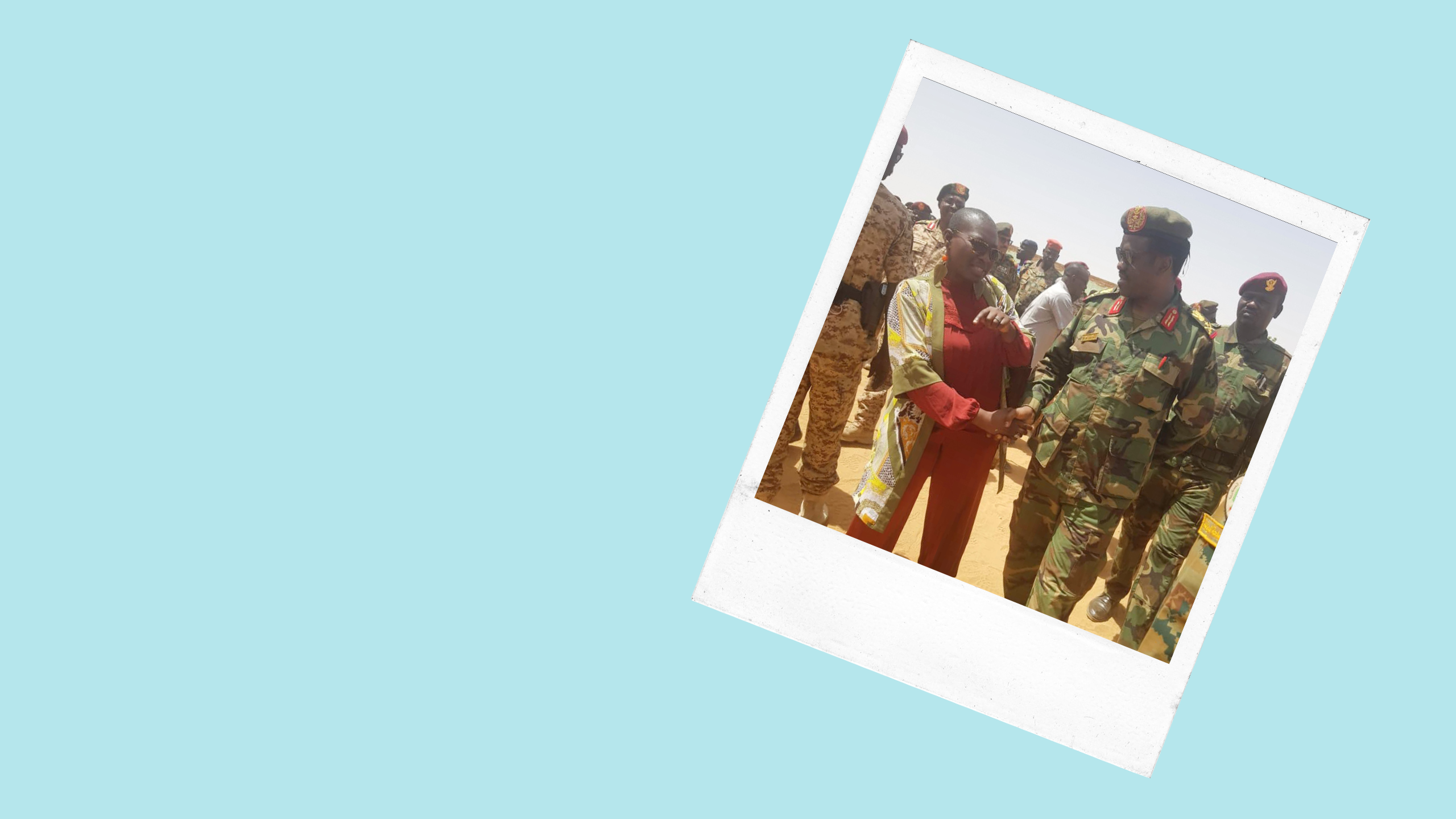 a woman shakes the had of man dressed in military fatigues