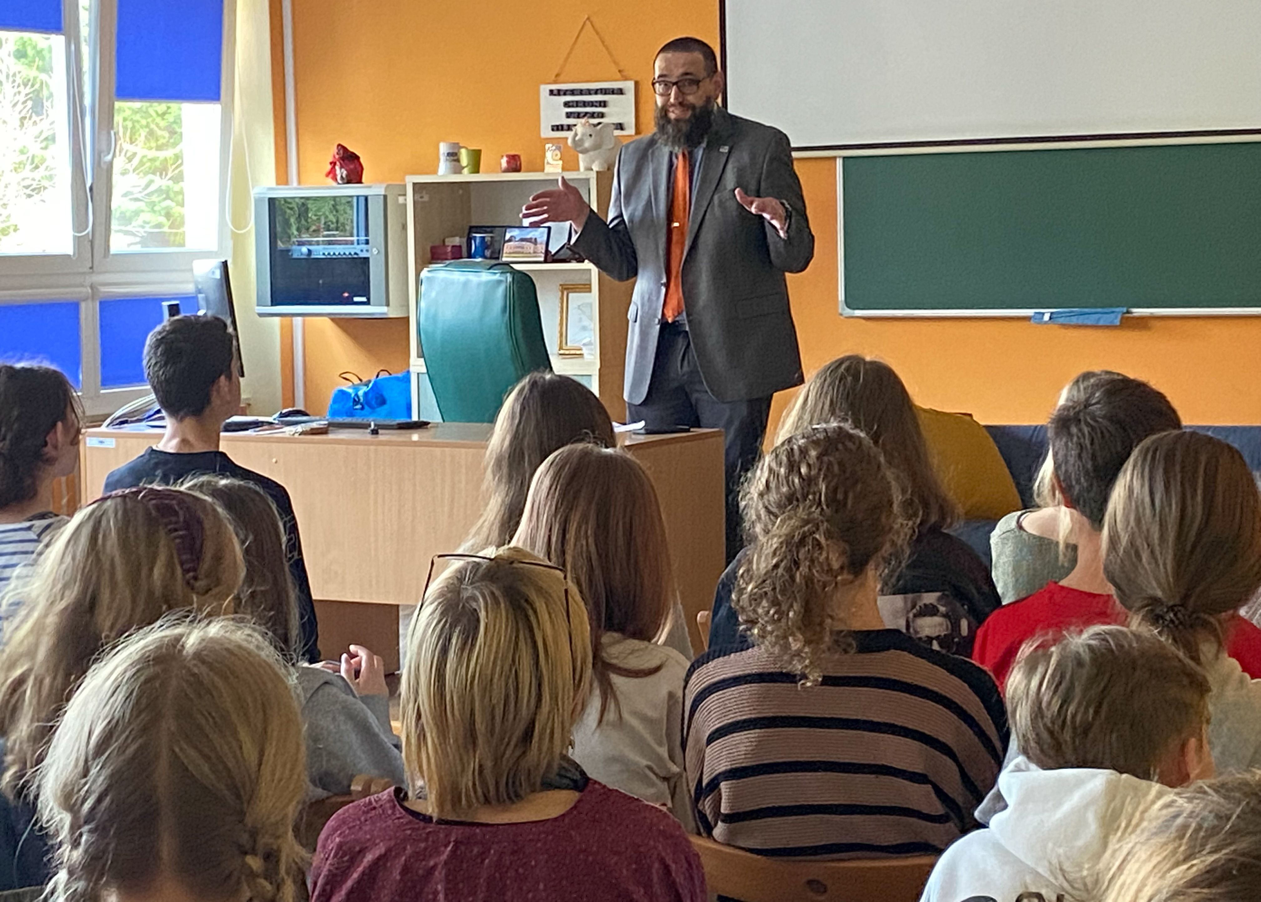 a man addresses a classroom of high school students