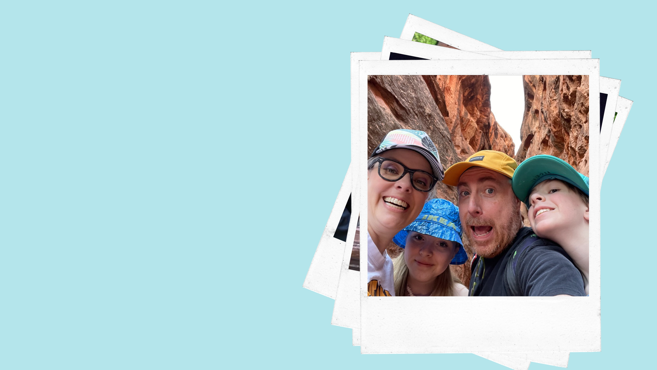 two adults and two children pose for a photo in a red rock canyon