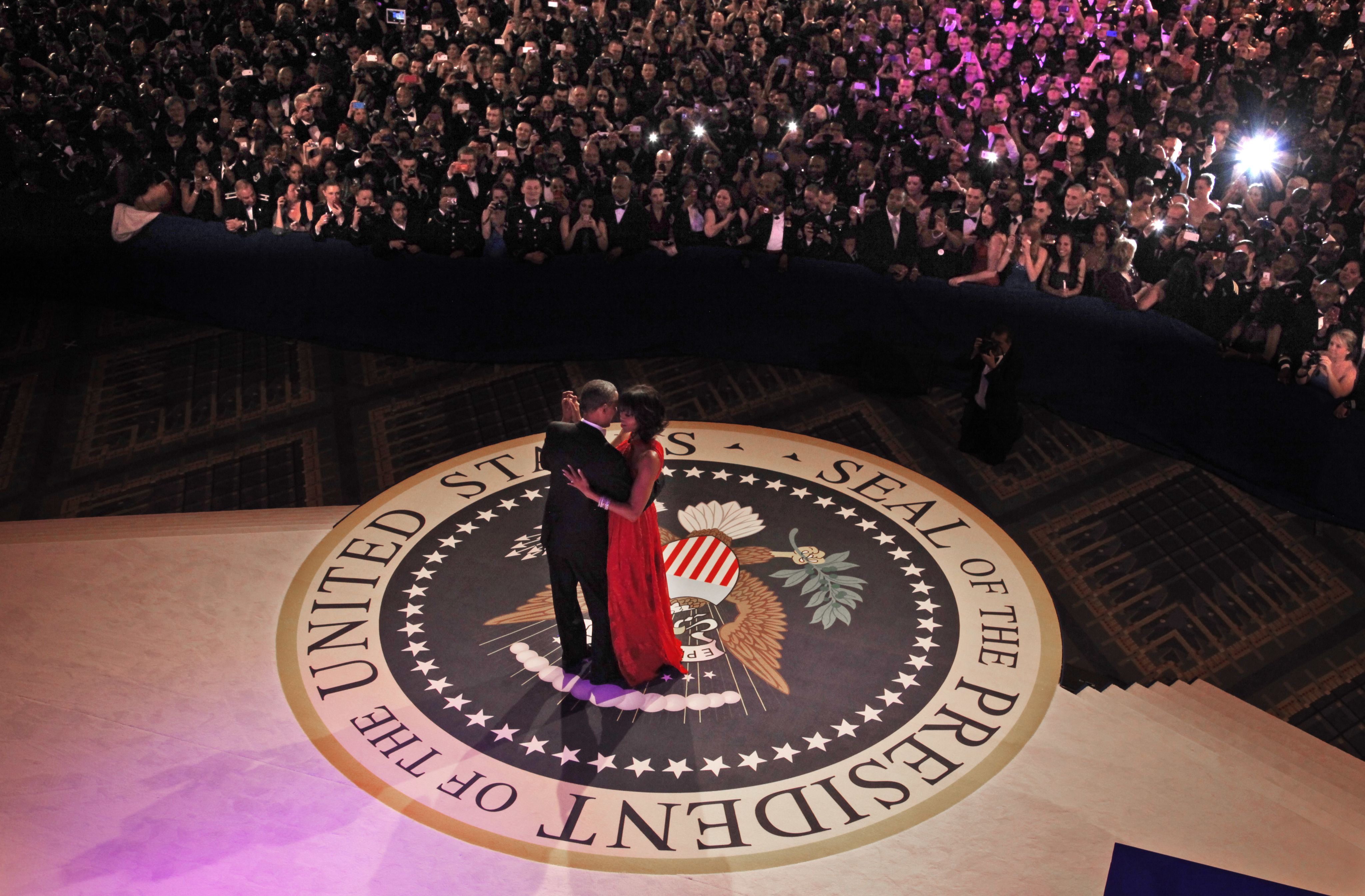 Barack and Michelle Obama dancing alone on floor with presidential seal, with onlookers some distance away (© Pablo Martinez Monsivais/AP)