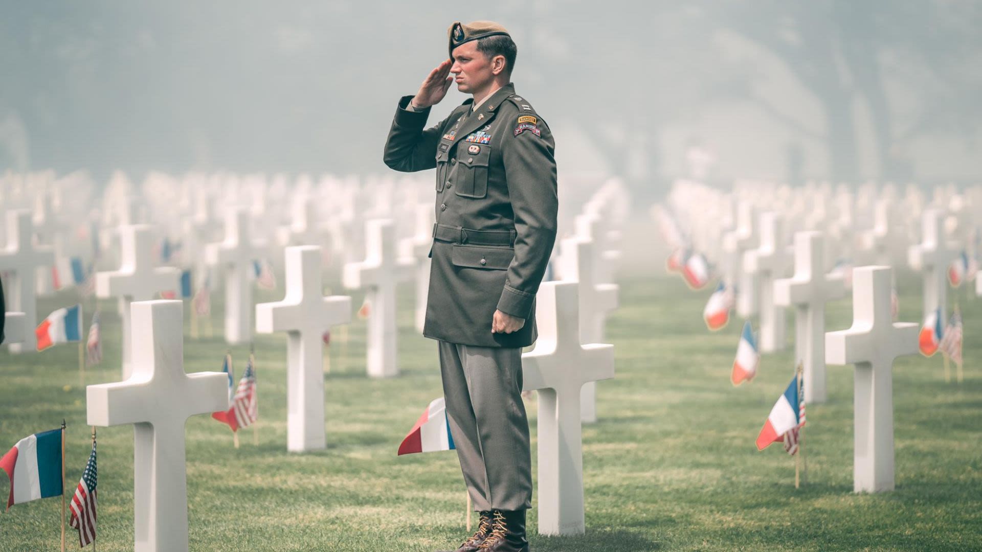 Man in military uniform saluting among headstones at Normandy American Cemetery and Memorial (U.S. Army/Sergeant 1st Class Jorden Weir)
