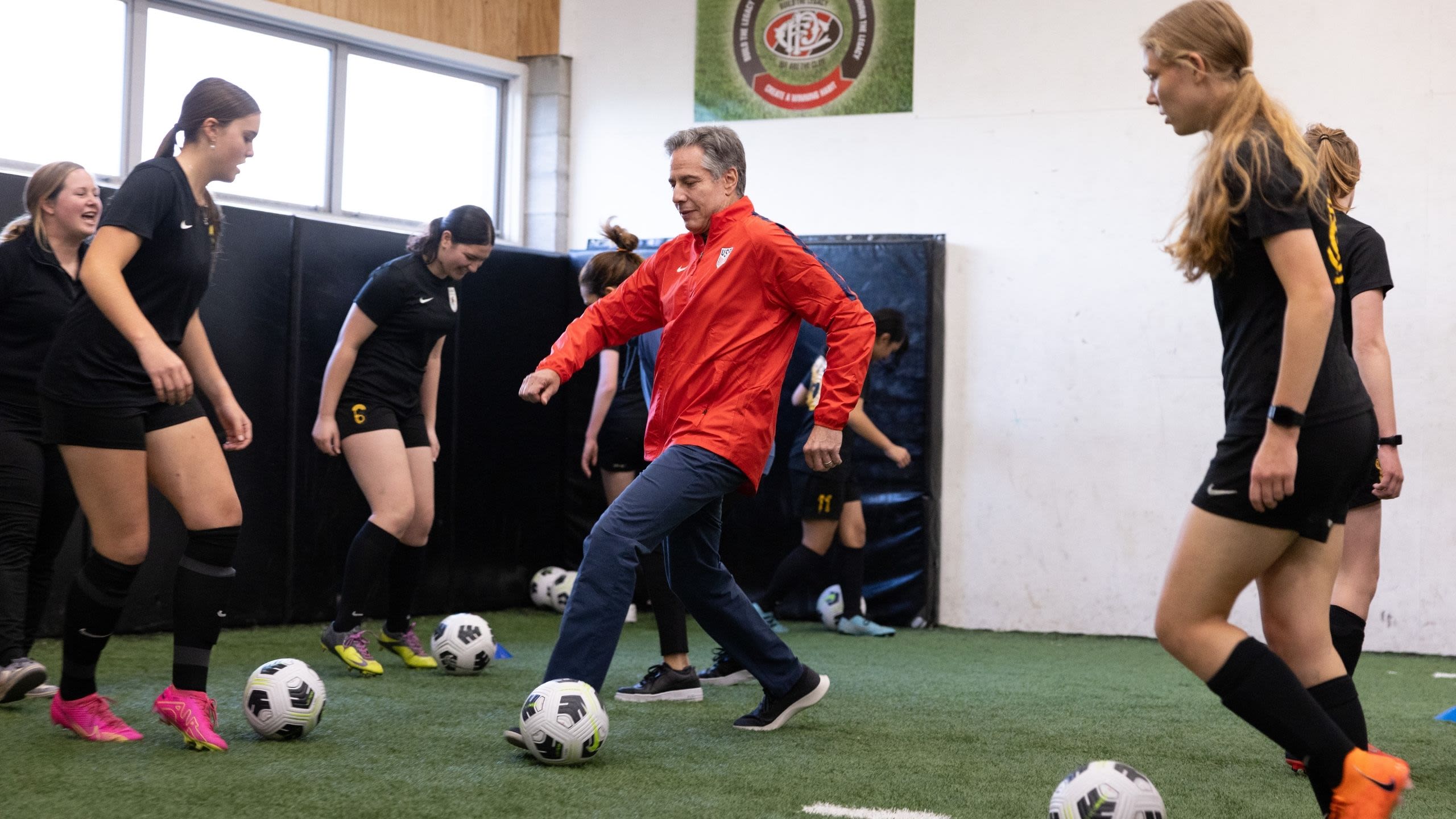 Secretary Blinken playing soccer with a group of women