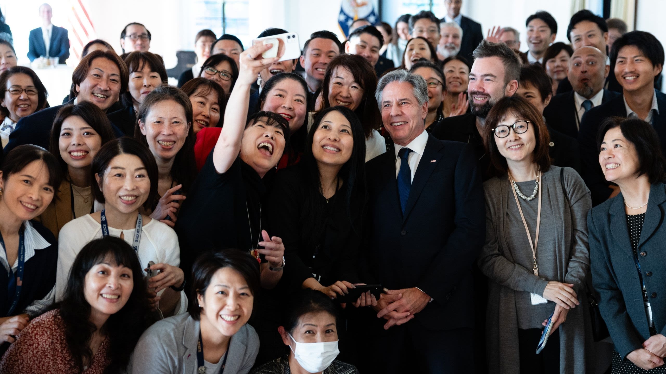 Secretary Blinken posing for a photograph with a group of people