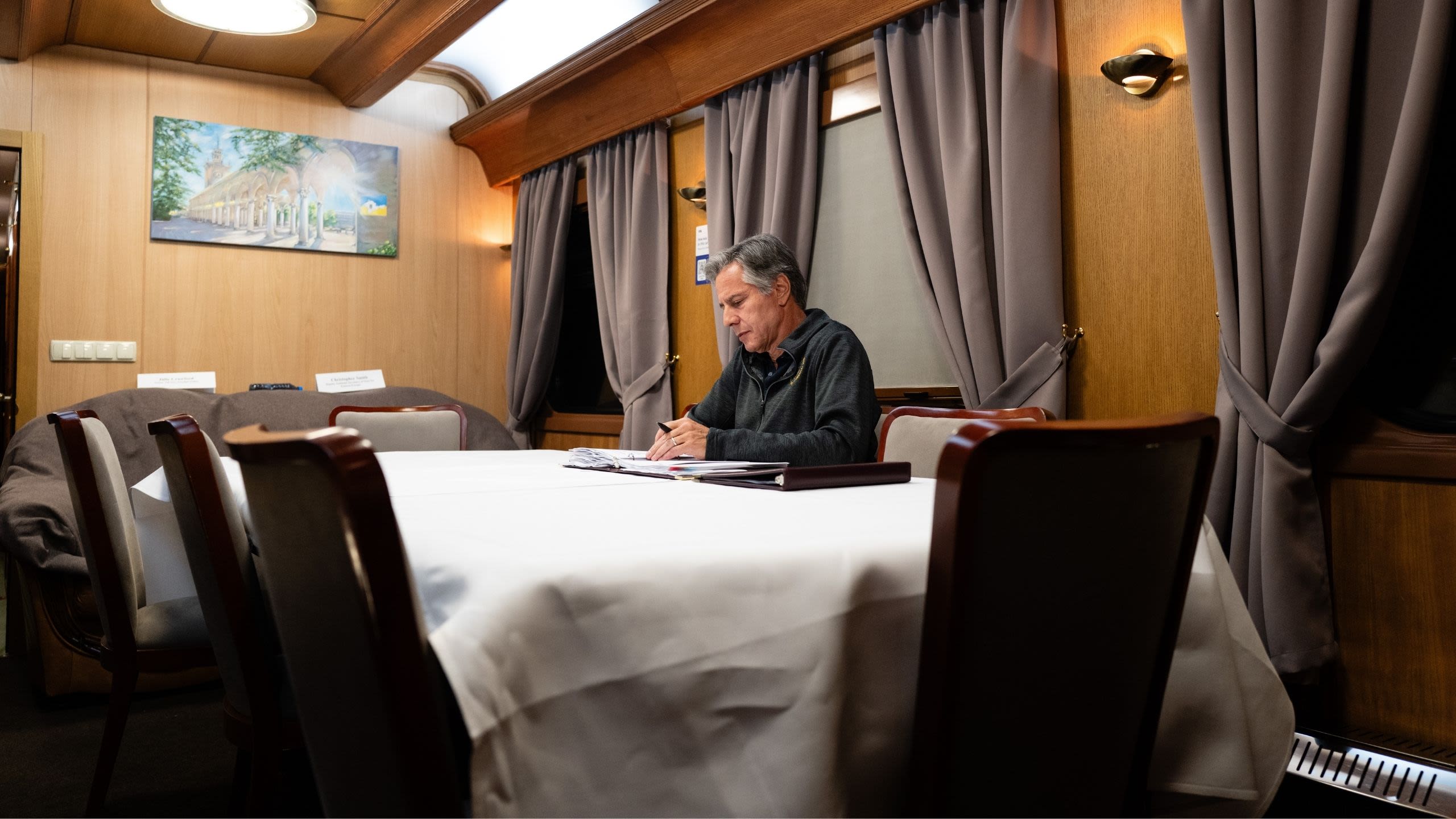 Secretary Blinken working at a table on a train