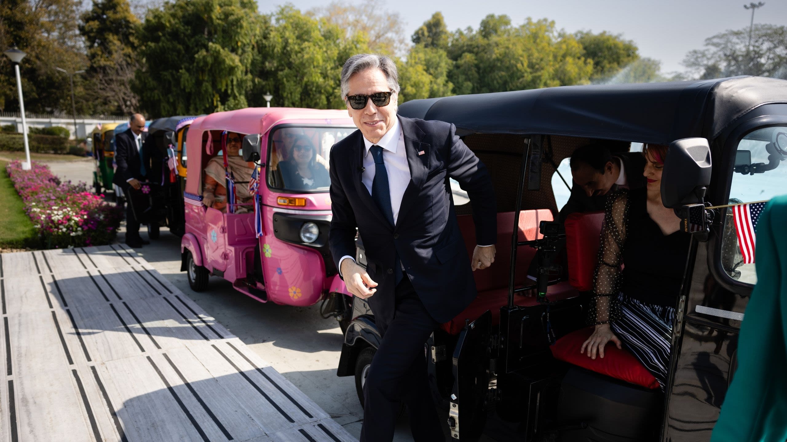 Secretary Blinken emerging from an auto rickshaw