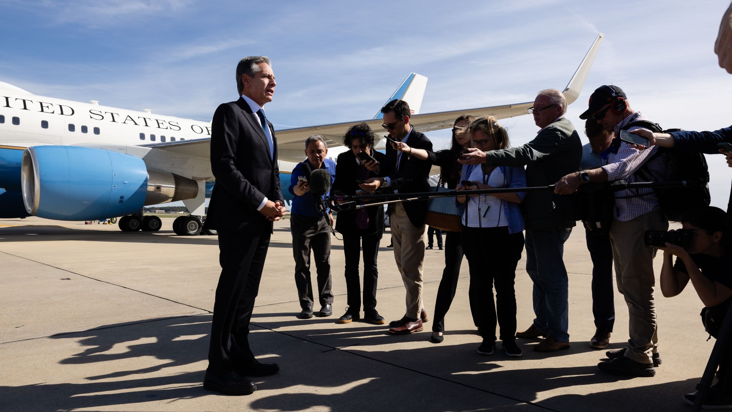 Secretary Blinken speaking to reporters on a tarmac