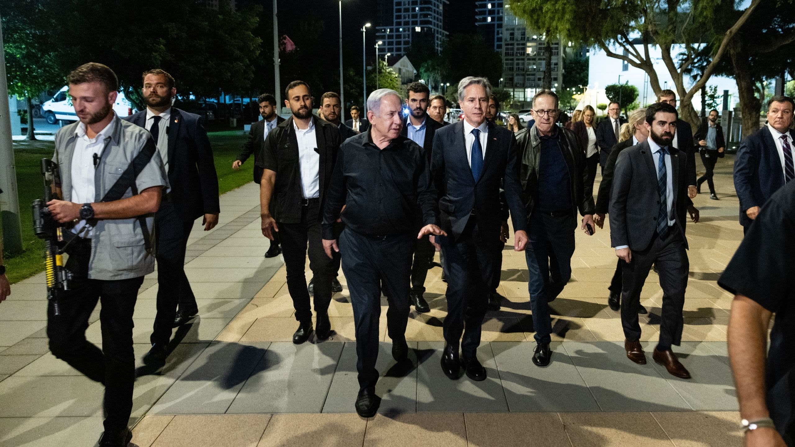 Prime Minister Netanyahu and Secretary Blinken walking in a street surrounded by staff and security