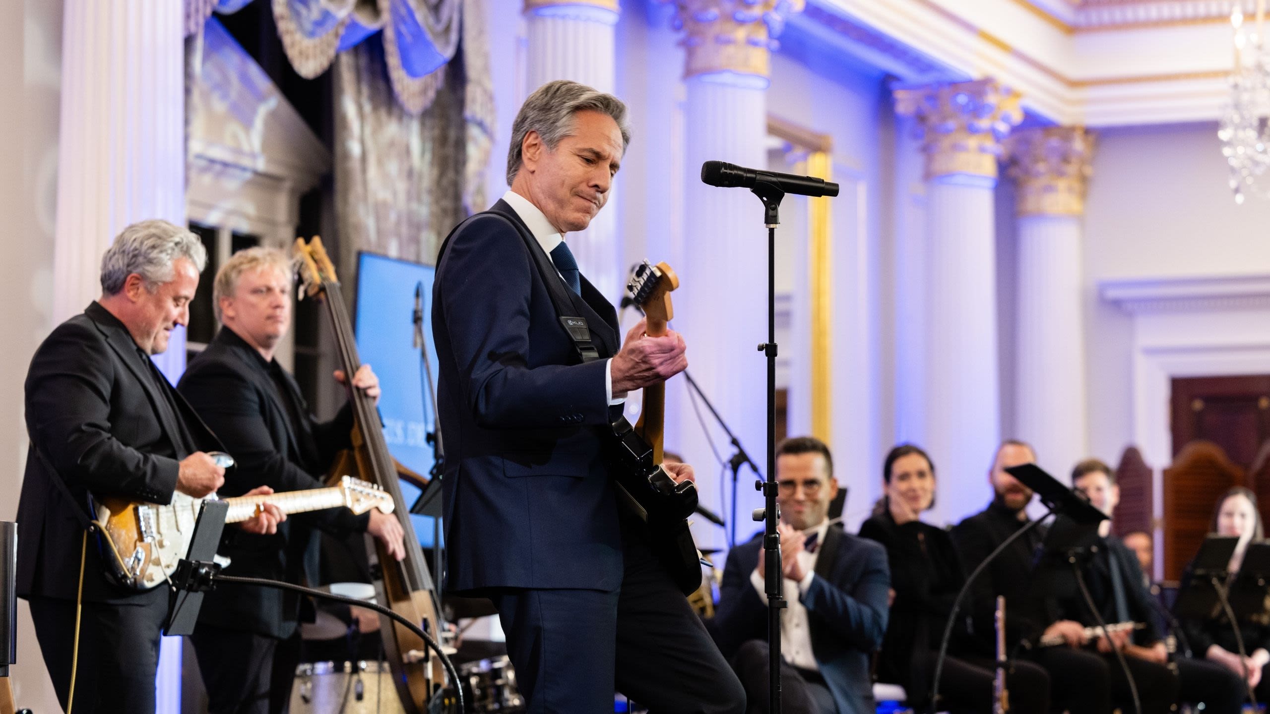 Secretary Blinken playing the guitar on stage
