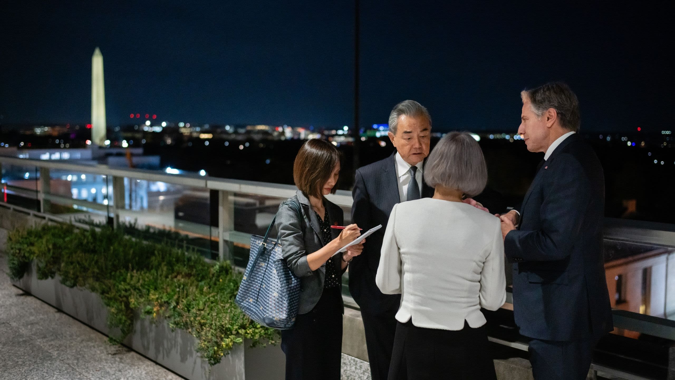 Foreign Minister Wang Yi talking with Secretary Blinken while 2 translators take notes