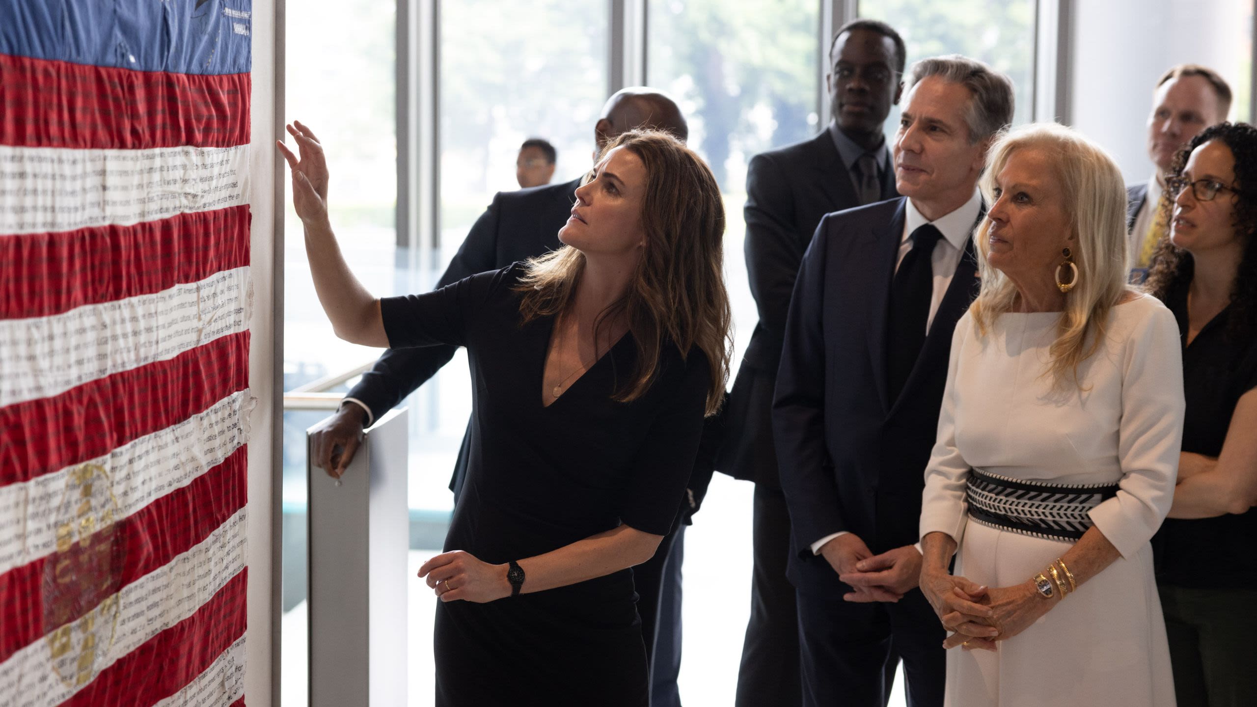 Group of people standing around Secretary Blinken