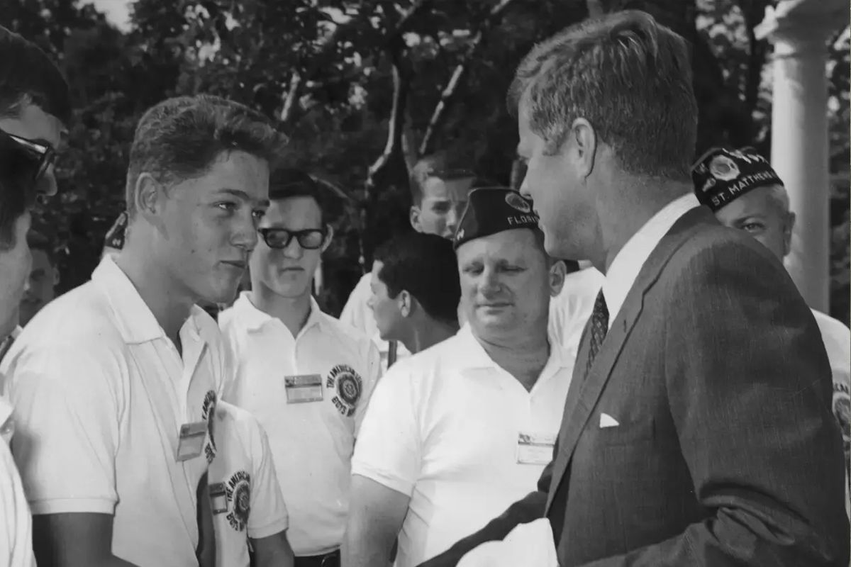 Future president Bill Clinton, as a teenage boy, shaking hands with President John F. Kennedy while other boys look on (© Arnold Sachs/Getty Images)
