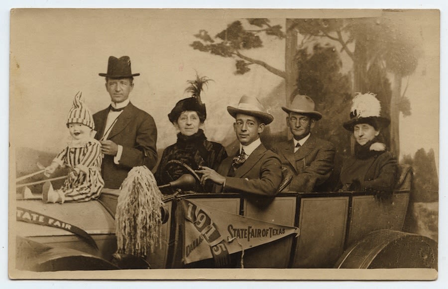 Vintage photo of five adults and a child posing in a 1915 State Fair of Texas car prop (© Hi-Story/Alamy)