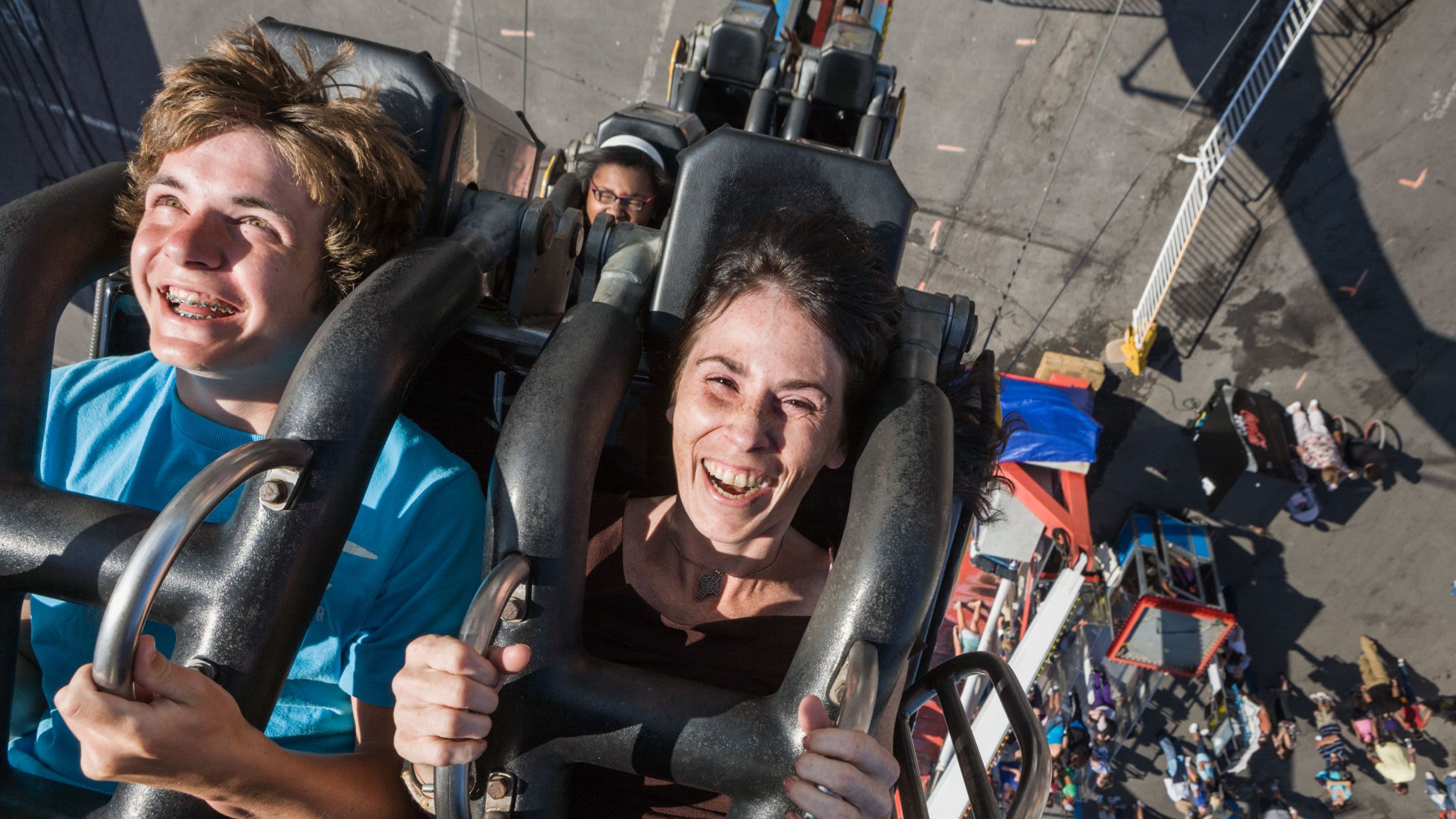 Woman and boy laughing on a high-speed thrill ride (© Alamy)