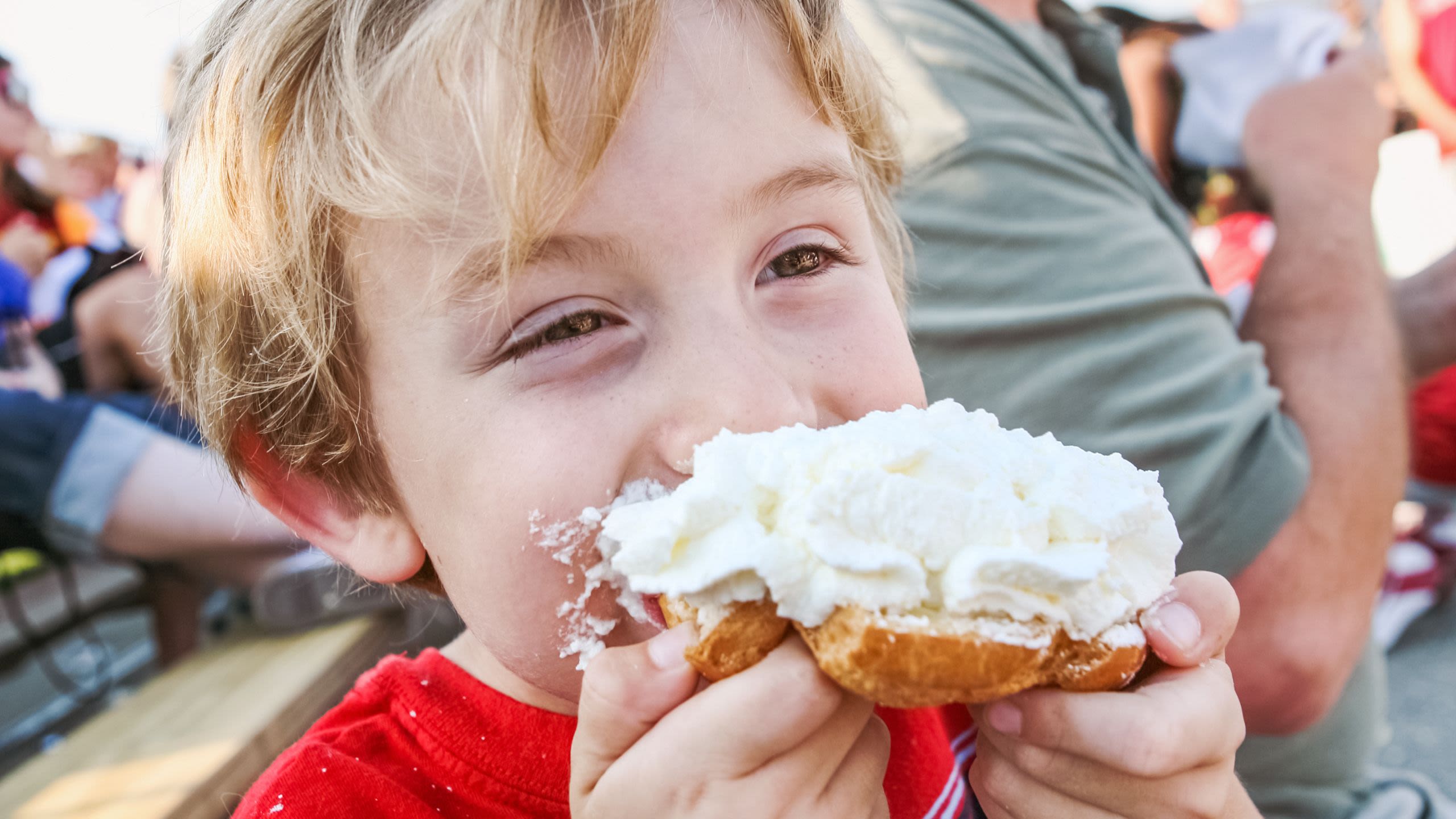 Smiling child eating a treat (© Suzanne Tucker/Shutterstock)