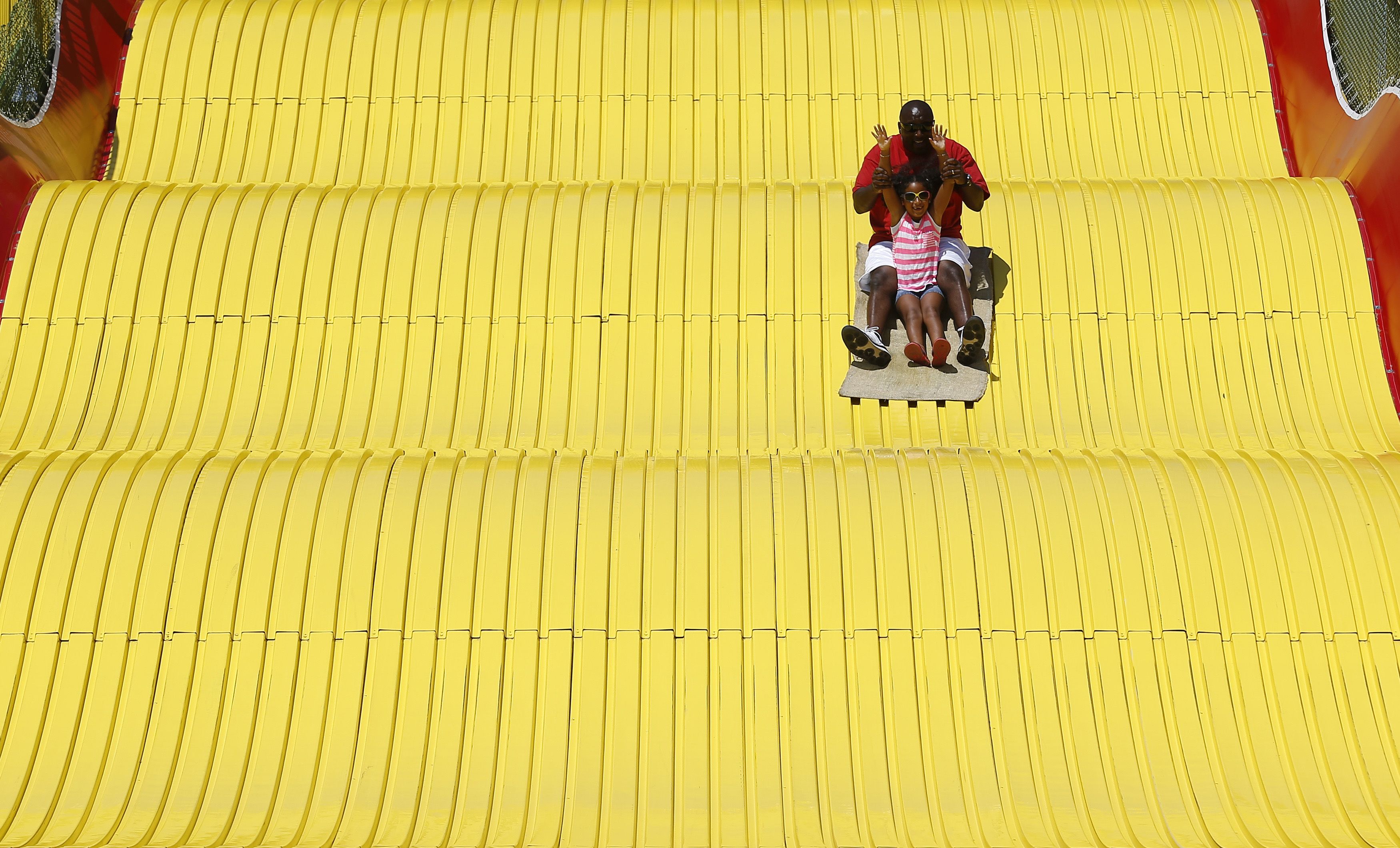 Man and child riding down a giant slide (© Jim Young/Reuters)