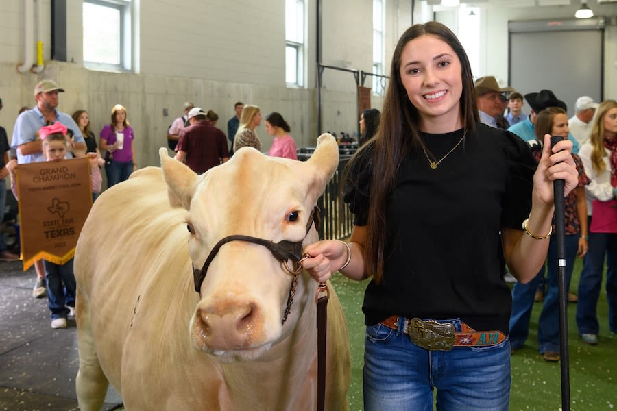 Smiling young woman with a prize-winning steer at a livestock show (Courtesy of State Fair of Texas)