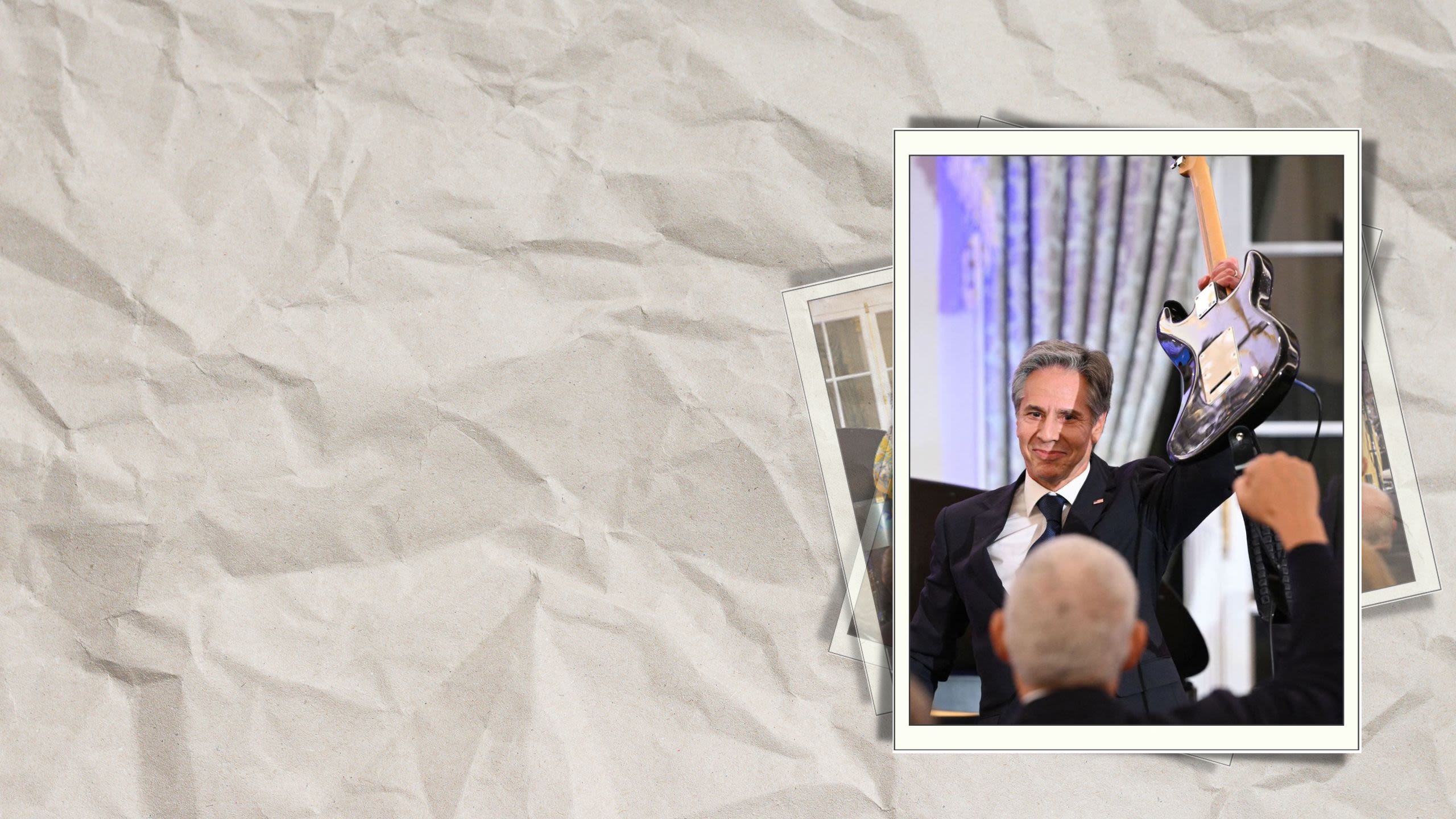 Secretary Blinken raising a guitar in the air (© Mandel Ngan/AFP/Getty Images)