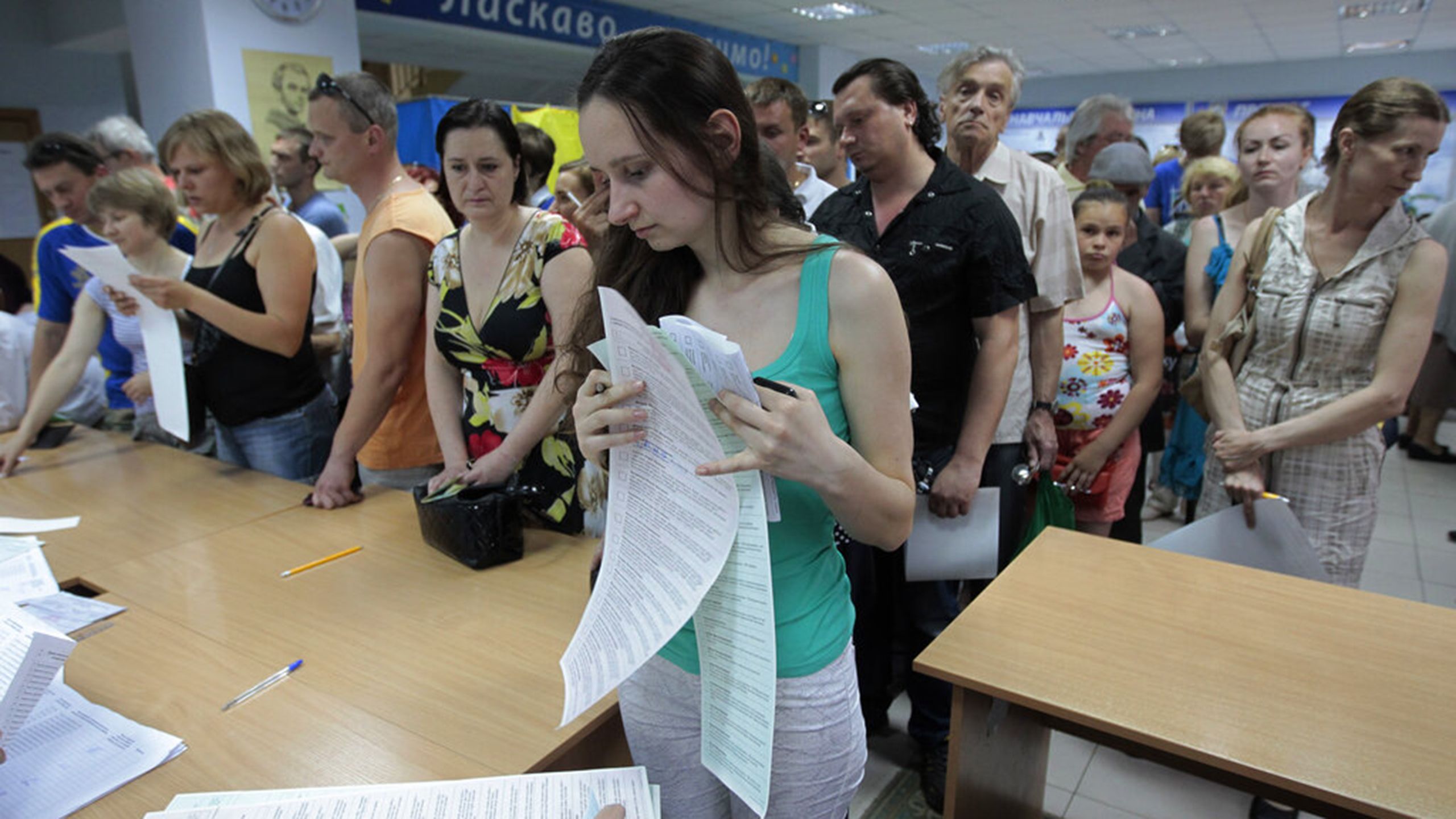 Une femme en tête de file, une longue feuille de papier à la main (© Sergei Chuzavkov/AP Photo)