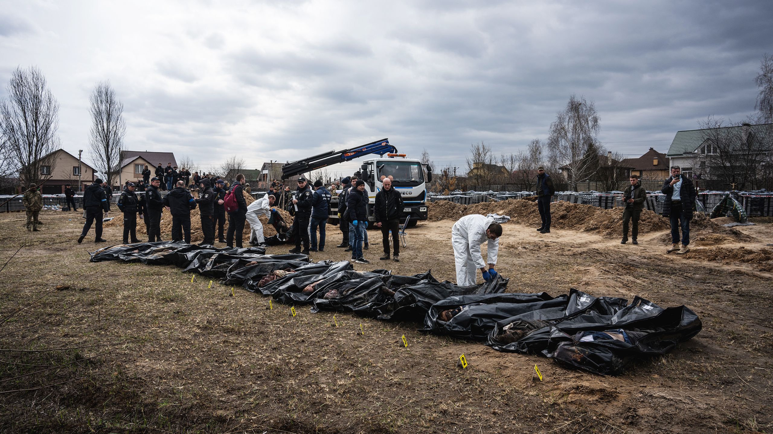 Des sacs mortuaires alignés sur le sol, et des hommes tout autour (© Andalou Agency/Getty Images)