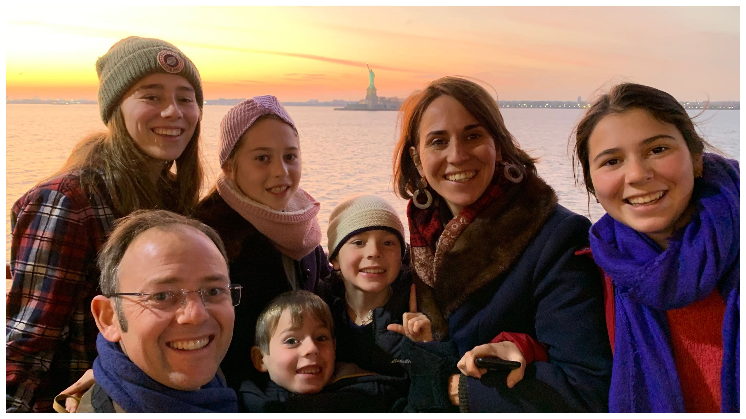 A family poses for a photograph with the Statue of Liberty in the background (Courtesy of Sébastien Fagart)