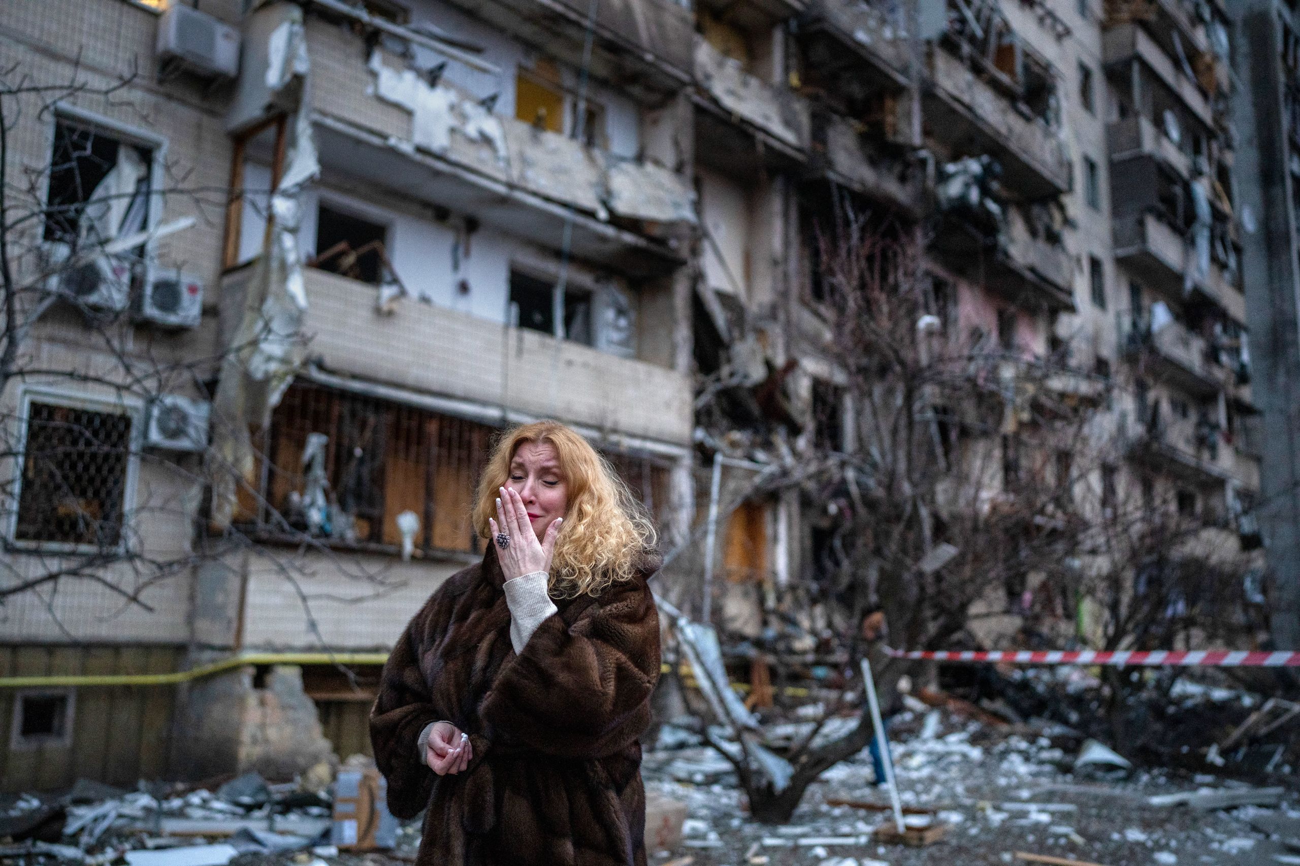 Natali Sevriukova reacts next to her home following a rocket attack on Kyiv, Ukraine, on February 25, 2022. (© Emilio Morenatti/AP Images)
