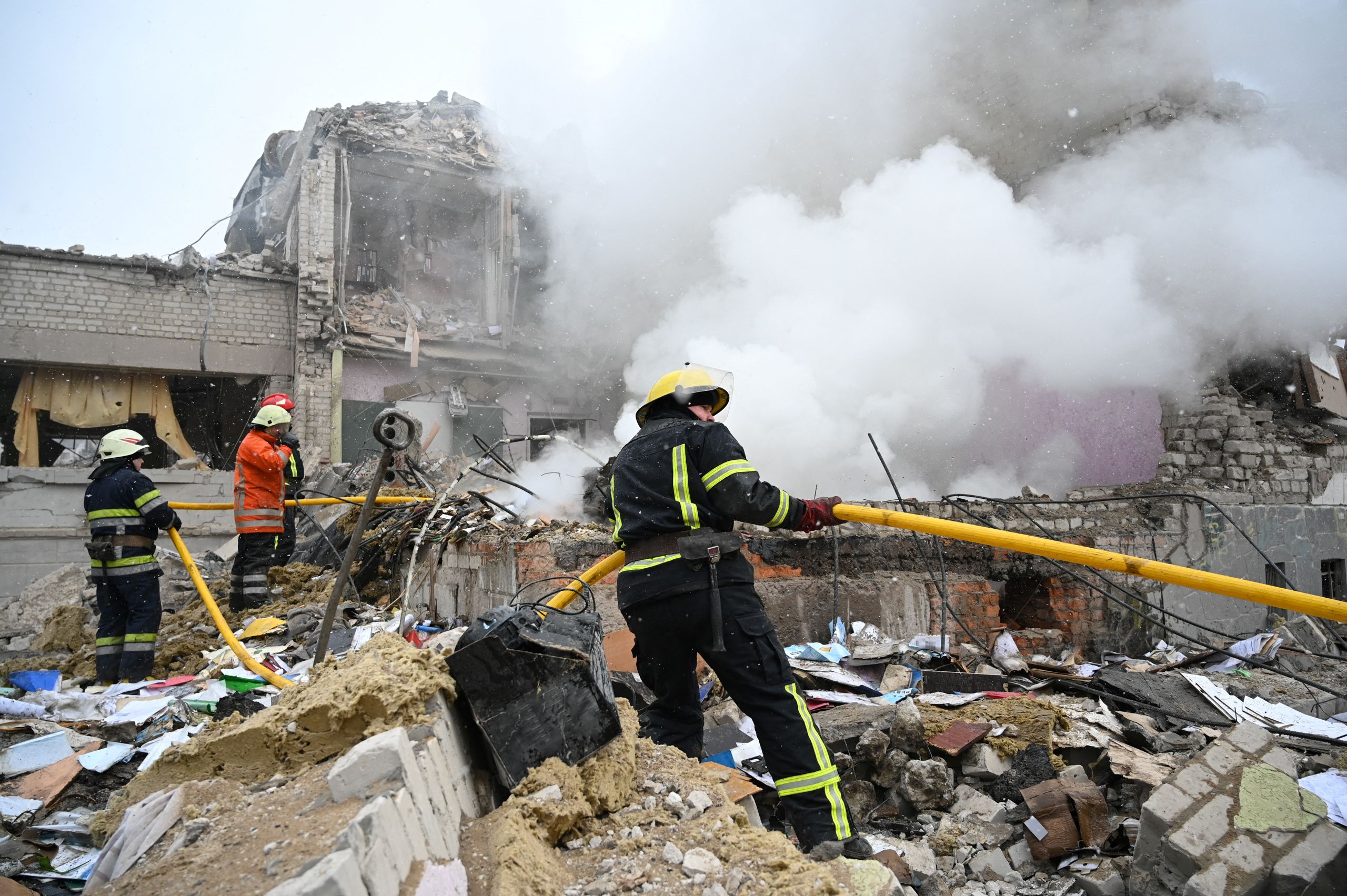 Rescuers work amid the debris of a school building destroyed by shelling in Zhytomyr, Ukraine, on March 4, 2022. (© Viacheslav Ratynskyi/Reuters)