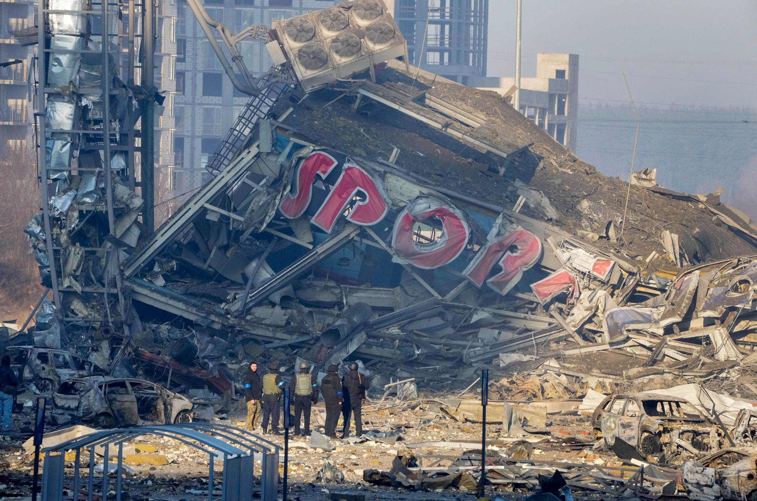 People examine the damage after the shelling of a shopping center in Kyiv, Ukraine, on March 21, 2022. At least eight people were killed in the attack. (© Efrem Lukatsky/AP Images)
