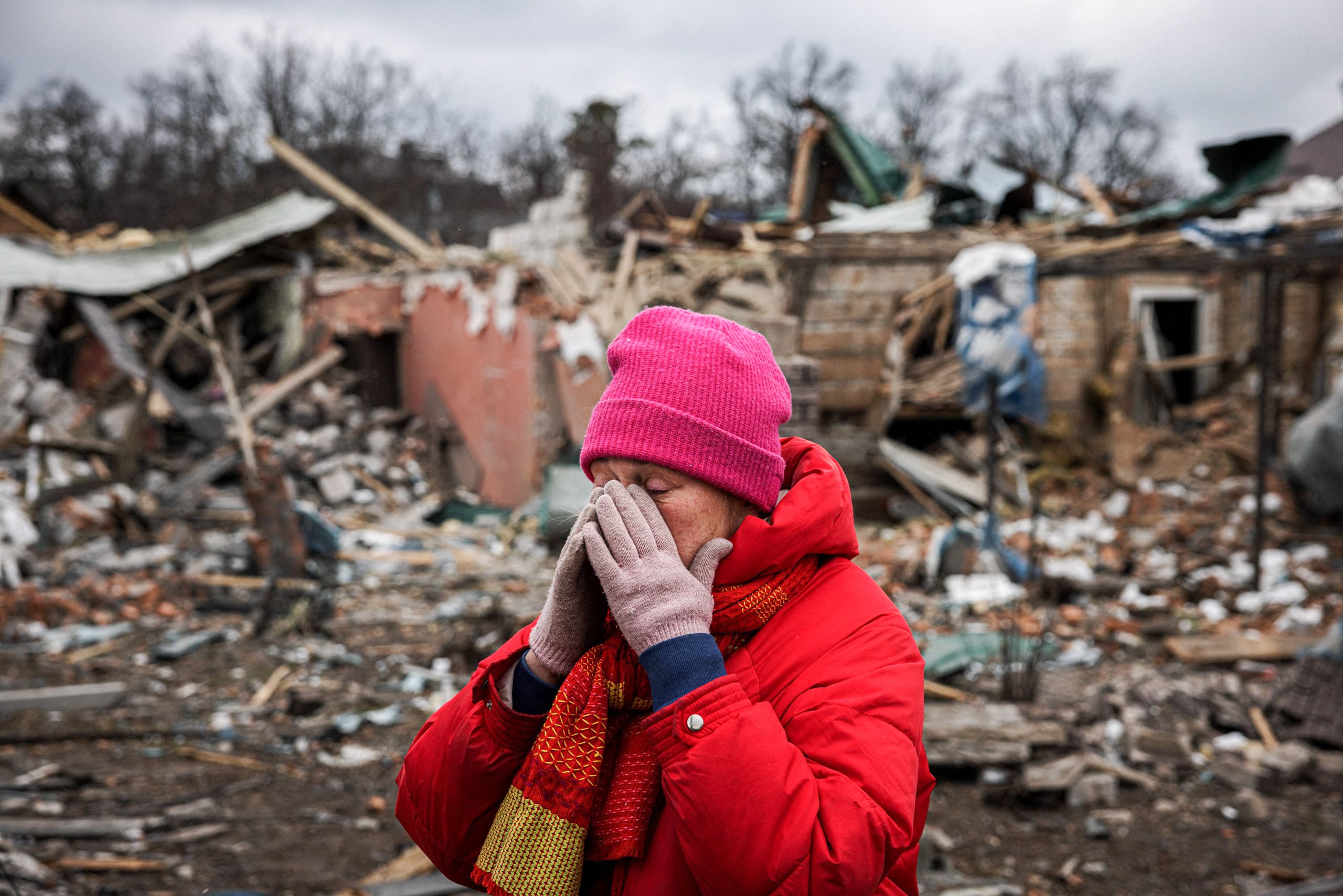Irina Moprezova, 54, reacts in front of a house that was damaged in an aerial bombing Irpin, northwest of Kyiv, Ukraine, on March 13, 2022. (© Dimitar Dilkoff/AFP/Getty Images)