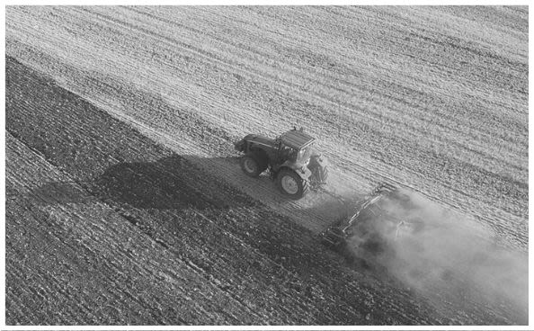Un homme conduisant un tracteur dans un champ.