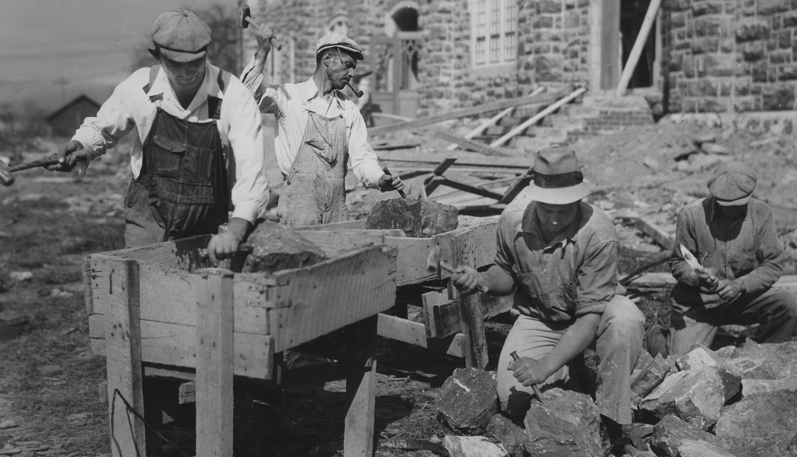 Stonemasons splitting and shaping rock at building site (© Archive Photos/Getty Images) 