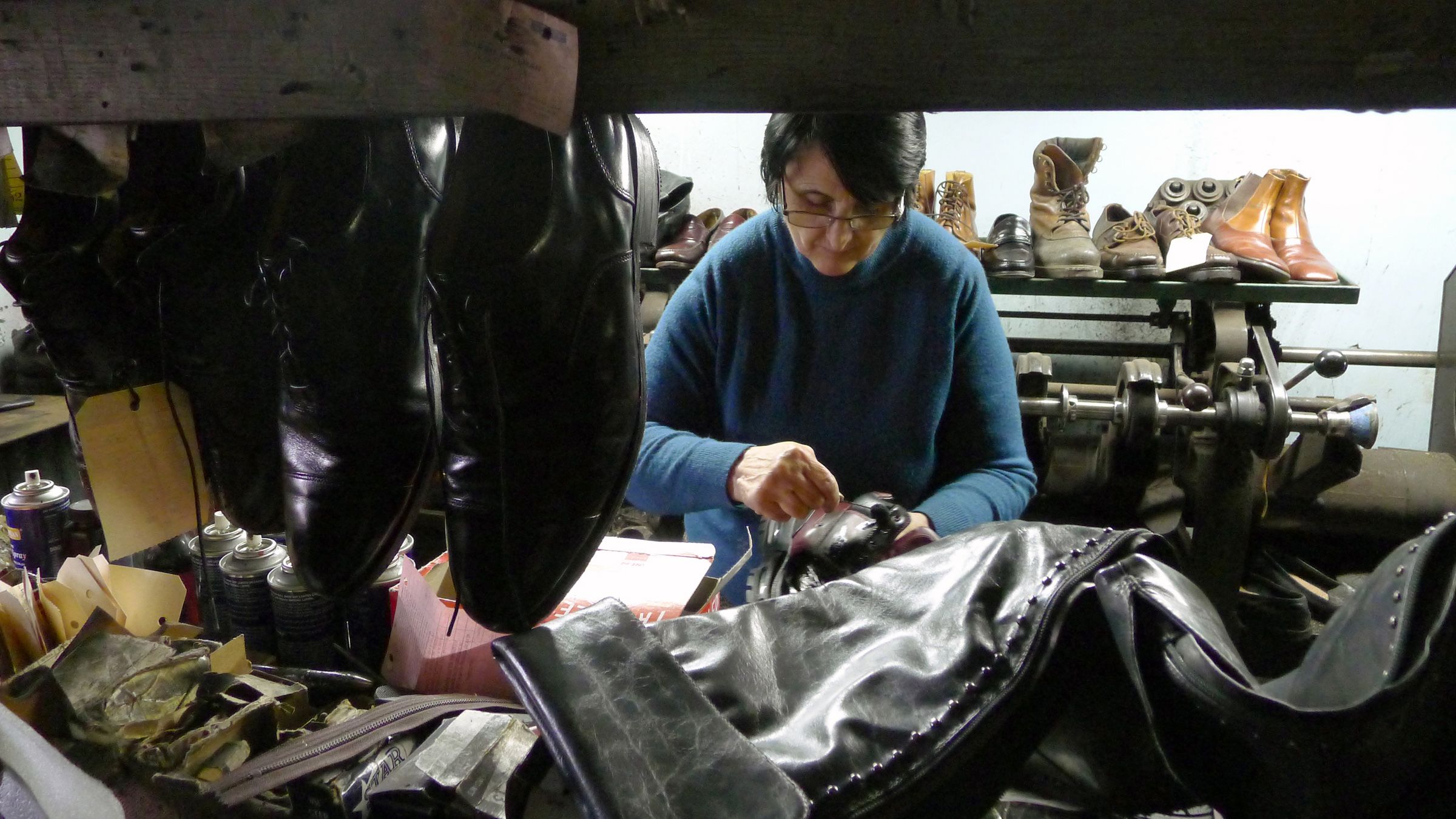 Cobbler repairing a leather shoe in a workshop filled with shoes (© Michael P. Farrell/Albany Times Union/Getty Images)