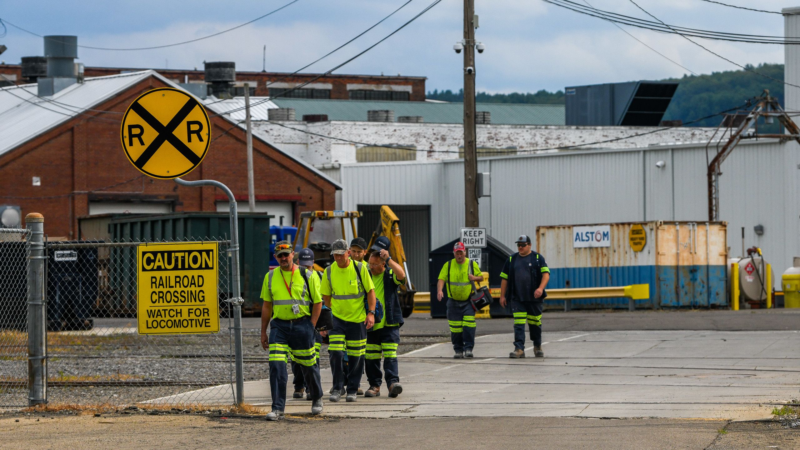 Workers in high-visibility vests walking past a railroad crossing (© Heather Ainsworth/The Washington Post/Getty Images)